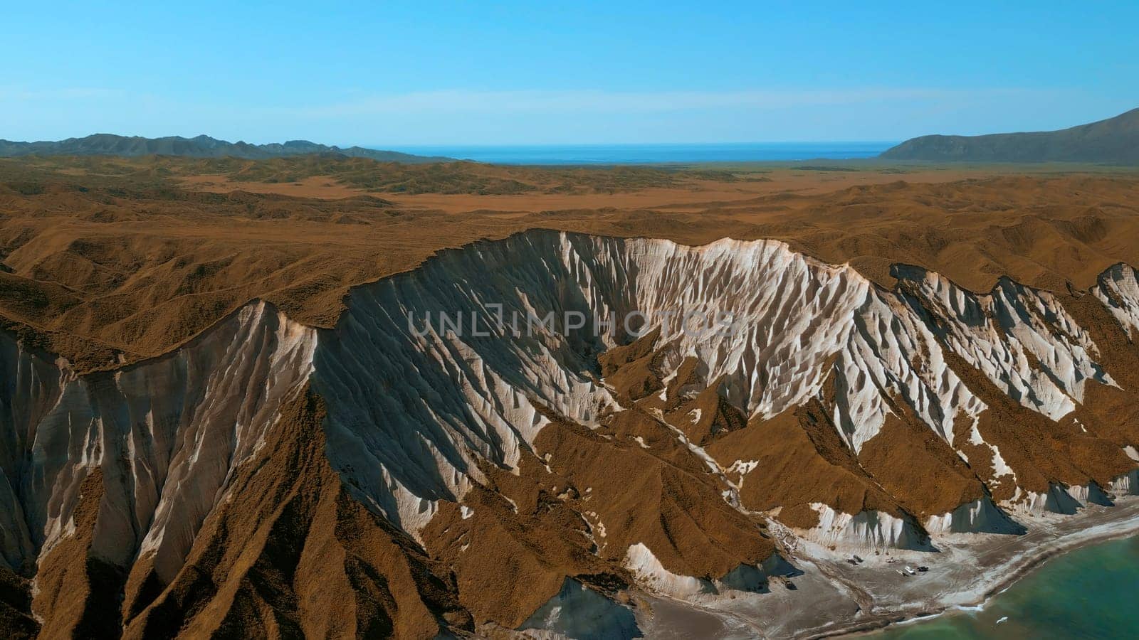 Aerial view of yellow grass field and beautiful rock formations. Clip. Sea shore and cliff. by Mediawhalestock