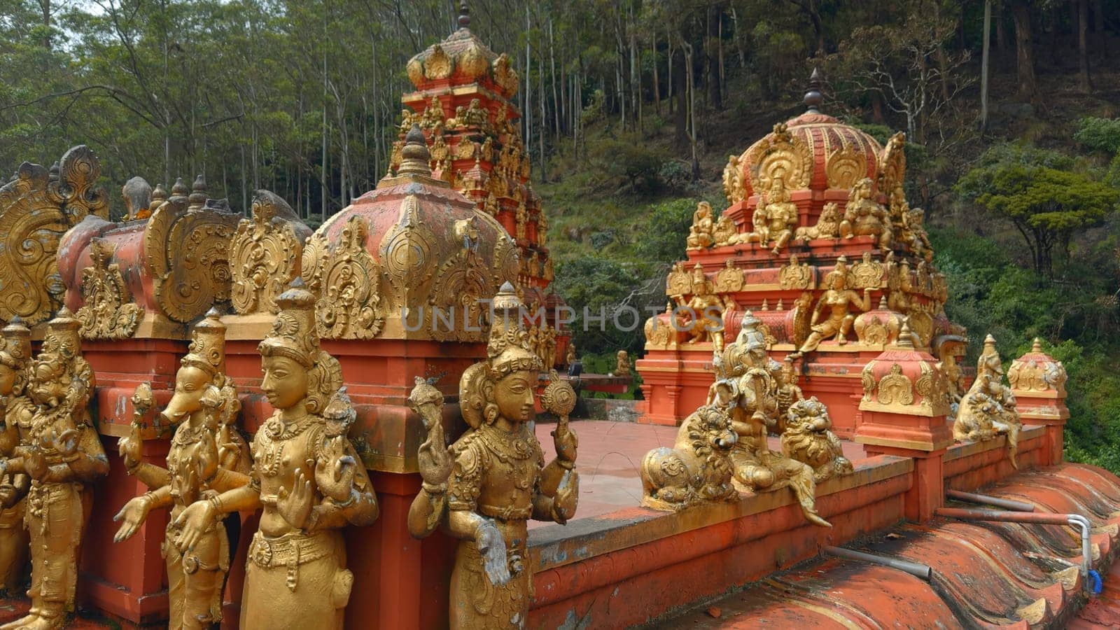 Hindu temple with golden statues. Action. Red temple with golden Buddhist statues. Temple of Hindu origin in Sri Lanka.