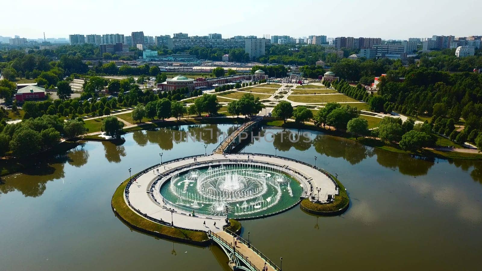 Top view of fountain in pond and historical palace. Creative. Amazing fountain in lake with pedestrian bridges at historical palace. Historical complex with fountains, gardens and buildings by Mediawhalestock
