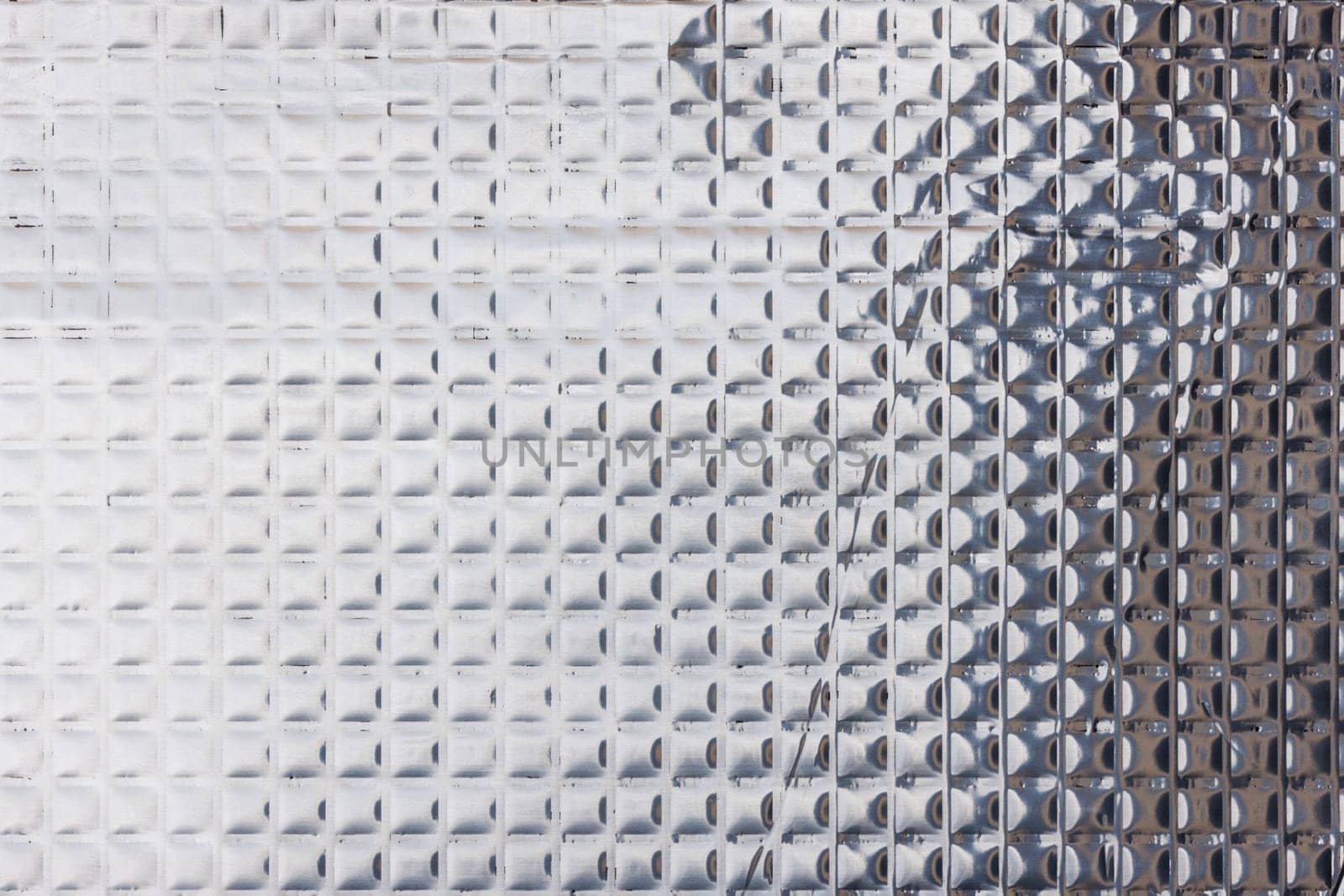 Closeup full-frame background and texture of aluminum coated butil rubber sheet with square pattern. by z1b