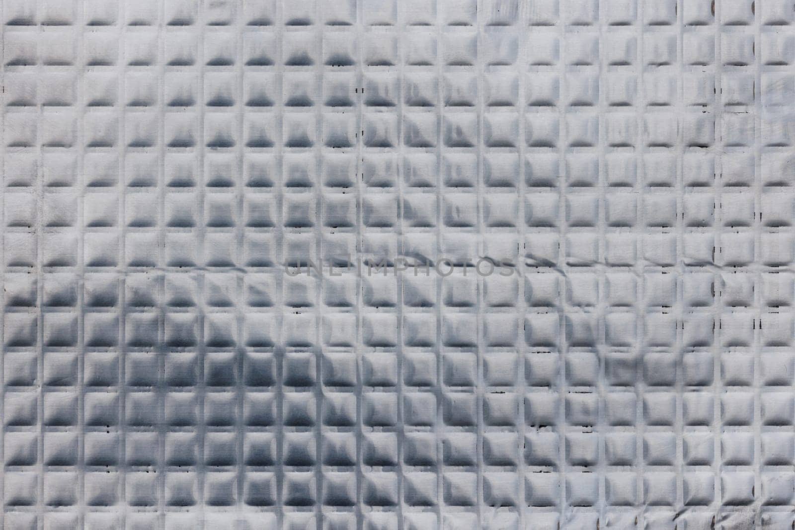 Closeup full-frame background and texture of aluminum coated butil rubber sheet with square pattern. by z1b