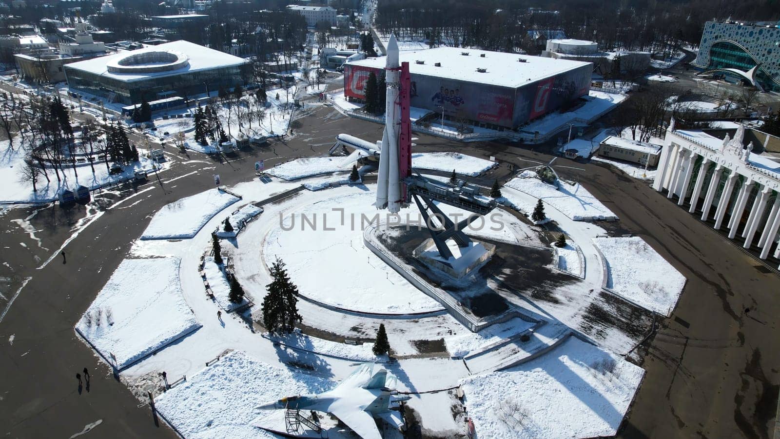 Top view of rocket monument in winter. Creative. Rocket monument on city square on sunny winter day. Large-scale monument to space flight with rocket on square by Mediawhalestock
