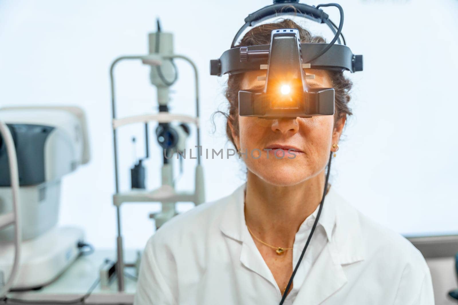 Frontal view of ophthalmologist using light of a retinoscope by Huizi
