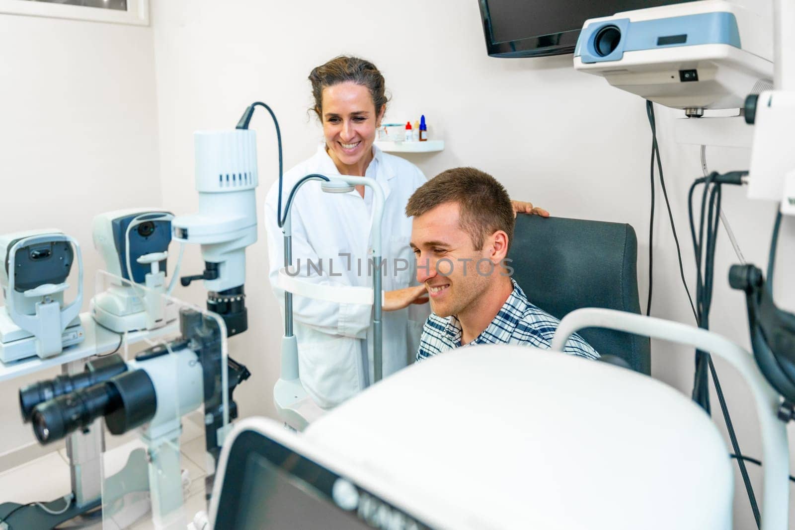 Smiling man on a medical appointment with ophthalmologist by Huizi