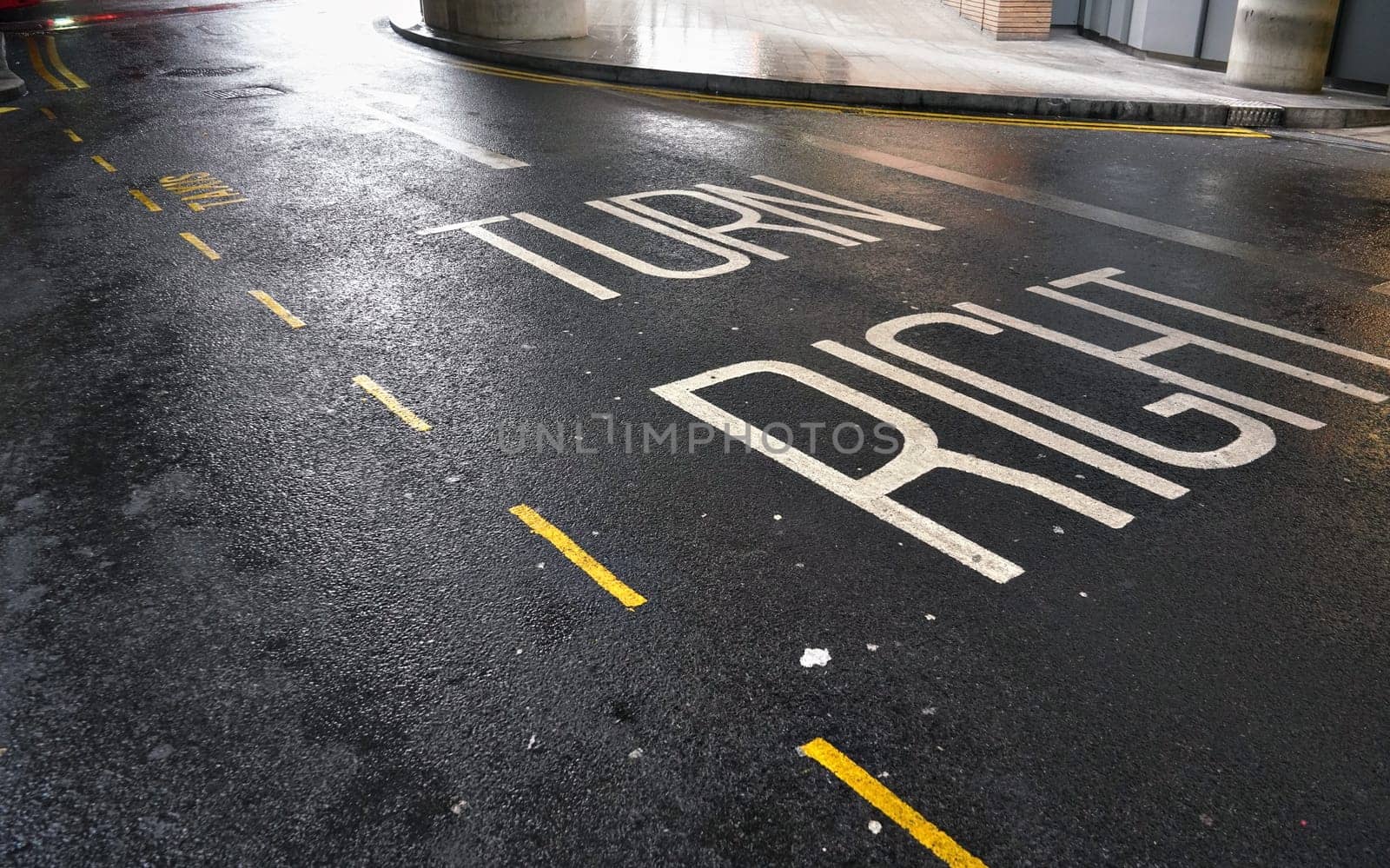 TURN RIGHT sign / text and yellow line on wet asphalt road