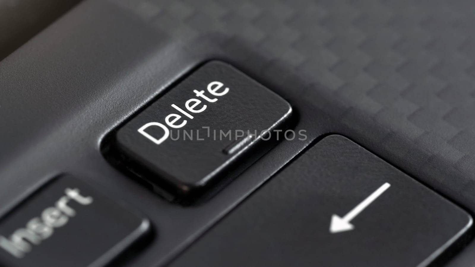 Closeup macro detail of Delete key on black laptop keyboard