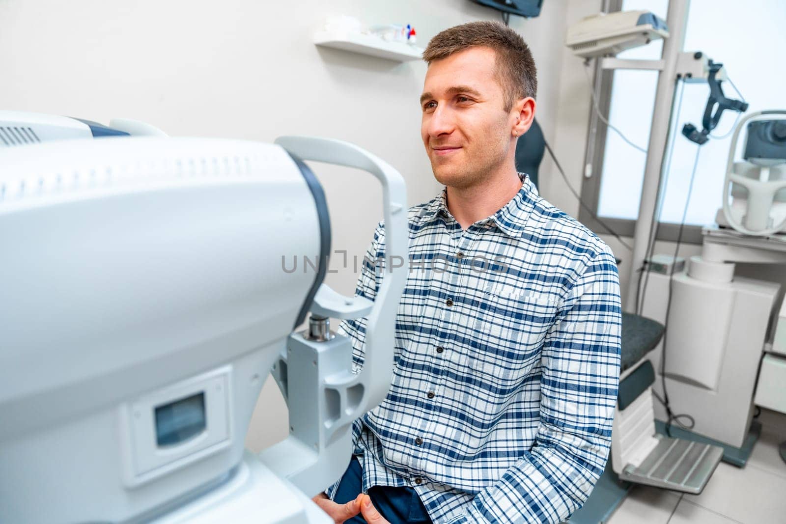 Man about to scan her eye in scanner machine in a clinic