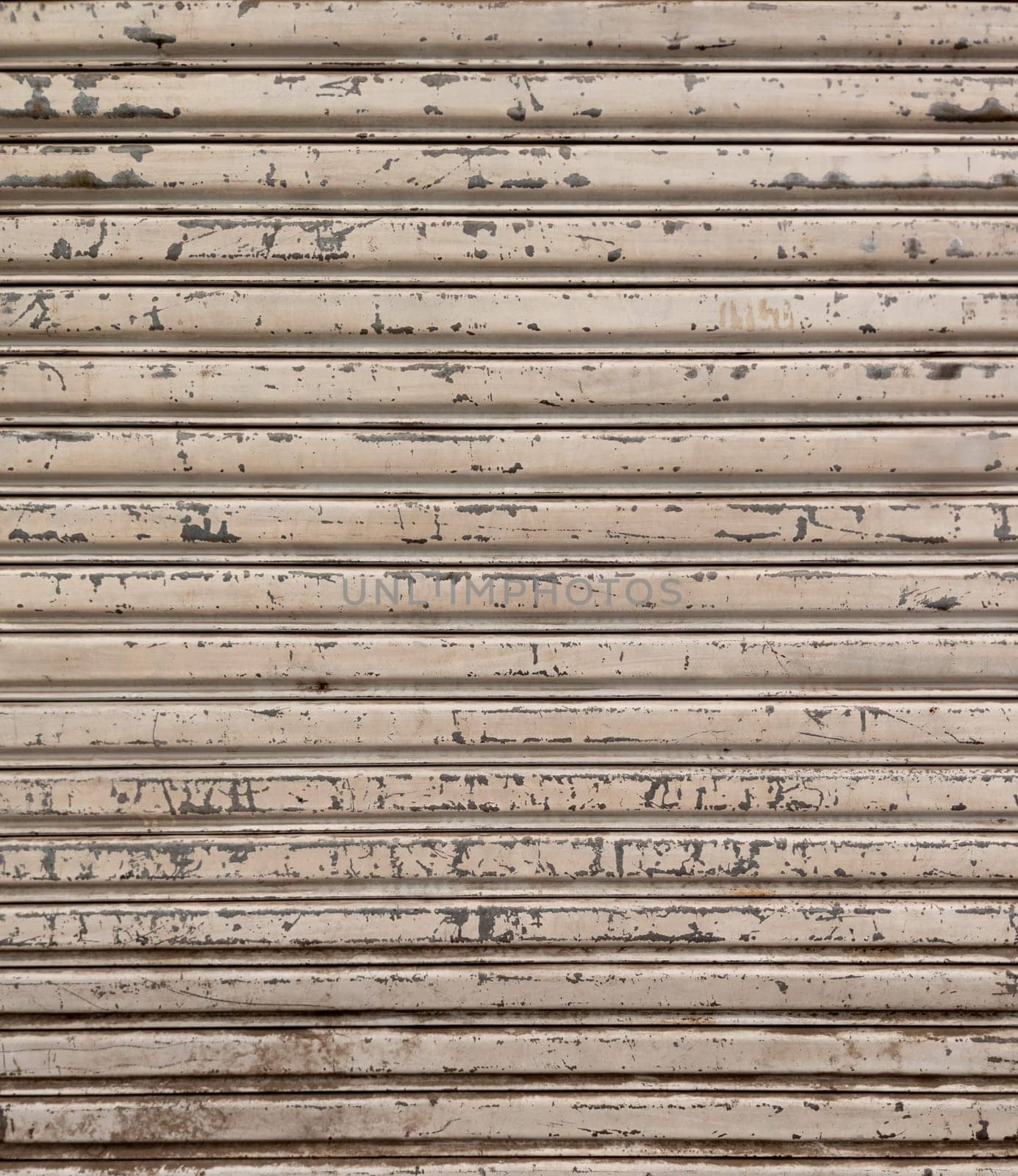 Closeup of a weathered and dirty metal shutter with horizontal folding lines