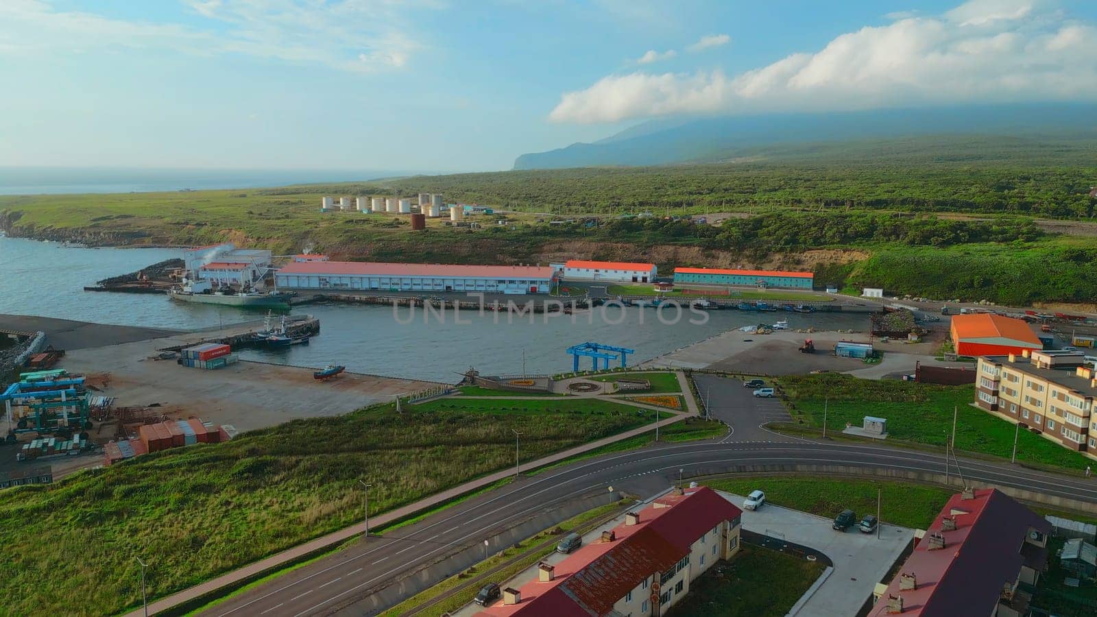 Top view of sea port with sand on north coast. Clip. infrastructure of seaport on seashore. Beautiful landscape of village with seaport on coast of mountain coast.