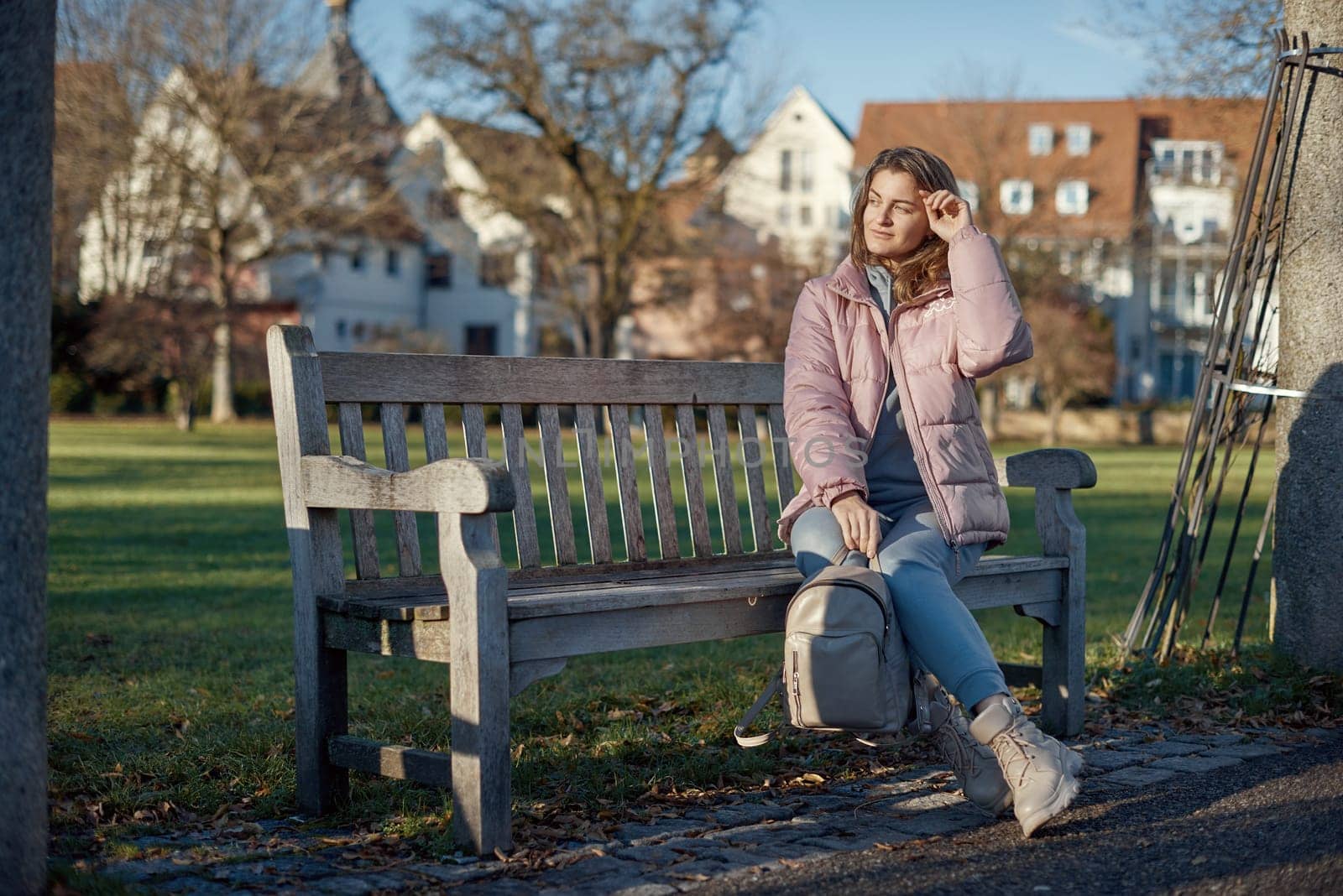 Experience the festive spirit of winter with this delightful image capturing a beautiful girl in a pink winter jacket sitting on a bench in a park, set against the backdrop of the historic town of Bitigheim-Bissingen, Baden-Wurttemberg, Germany. The scene features charming half-timbered houses, creating a picturesque blend of seasonal beauty and architectural charm. Winter Wonderland Elegance: Beautiful Girl in Pink Jacket Enjoys Festive Atmosphere in Bitigheim-Bissingen Park. Experience the magic of the holiday season as a charming girl in a pink winter jacket sits on a bench in a park against the backdrop of the historic town of Bitigheim-Bissingen, Baden-Wurttemberg, Germany. The scene is adorned with picturesque half-timbered houses, creating a delightful blend of winter charm and architectural beauty.