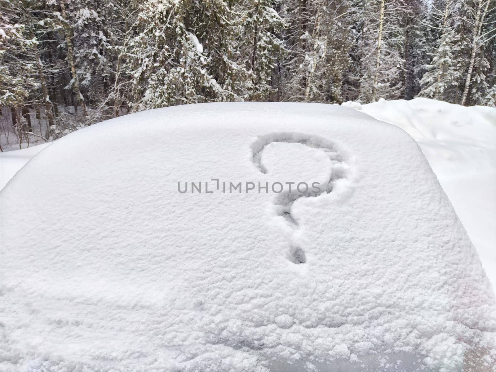 Question mark written in the snow on car. The cold frosty texture of the snow and the question mark. Background, place for text, copy space