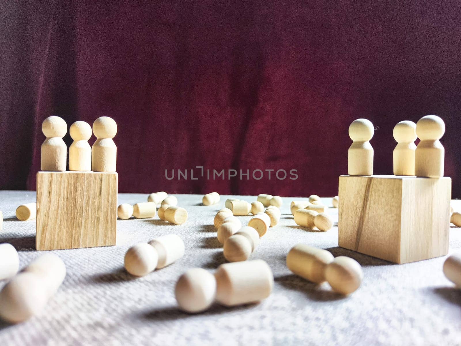 Wooden toys stand opposite and lot of lying figures. Concept of dispute between leaders of two groups. Government and deaths of citizens and soldiers. War in Russia, Ukraine, Israel, Palestine
