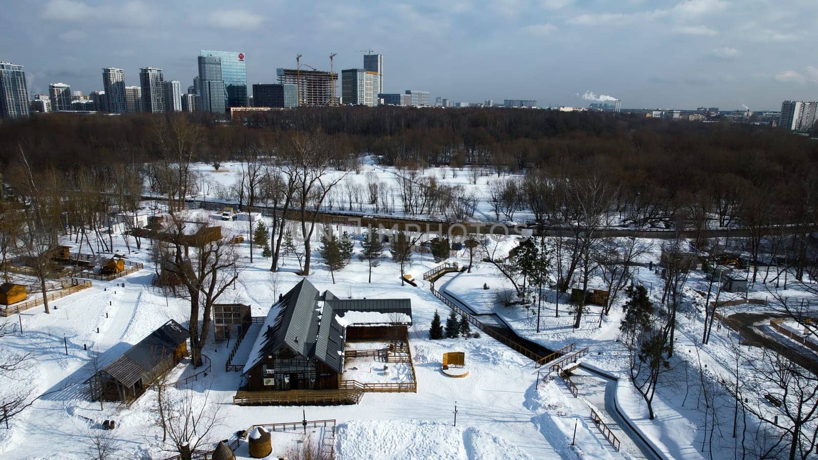 Top view of cottage town in suburbs in winter. Creative. Beautiful town with private houses in suburbs. Village near modern city on sunny winter day.