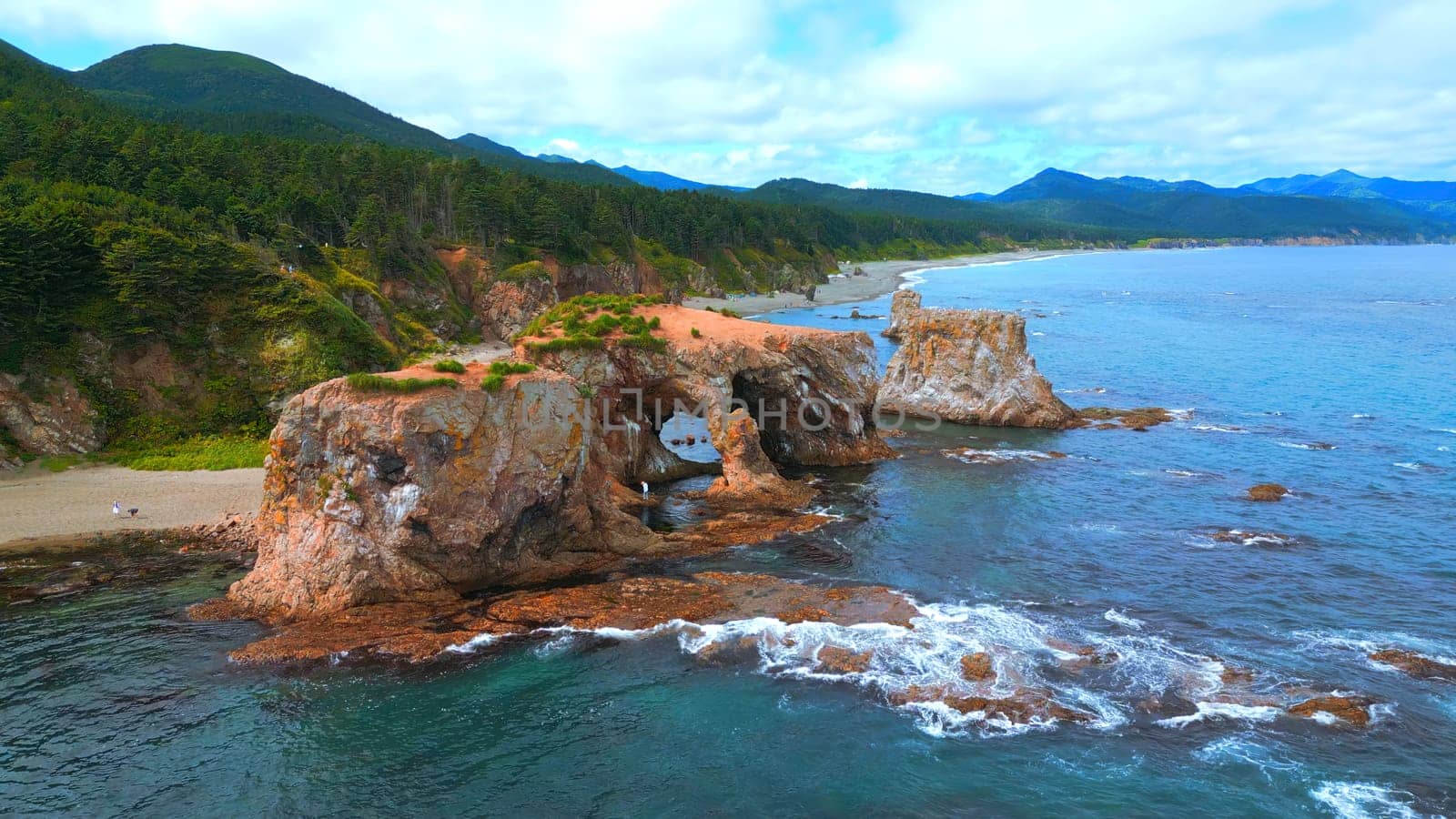 Top view of beautiful coast with rocky arches. Clip. Amazing nature of erosion in sea rocks on coast. Wild beach with coastal cliffs and stone arches by Mediawhalestock