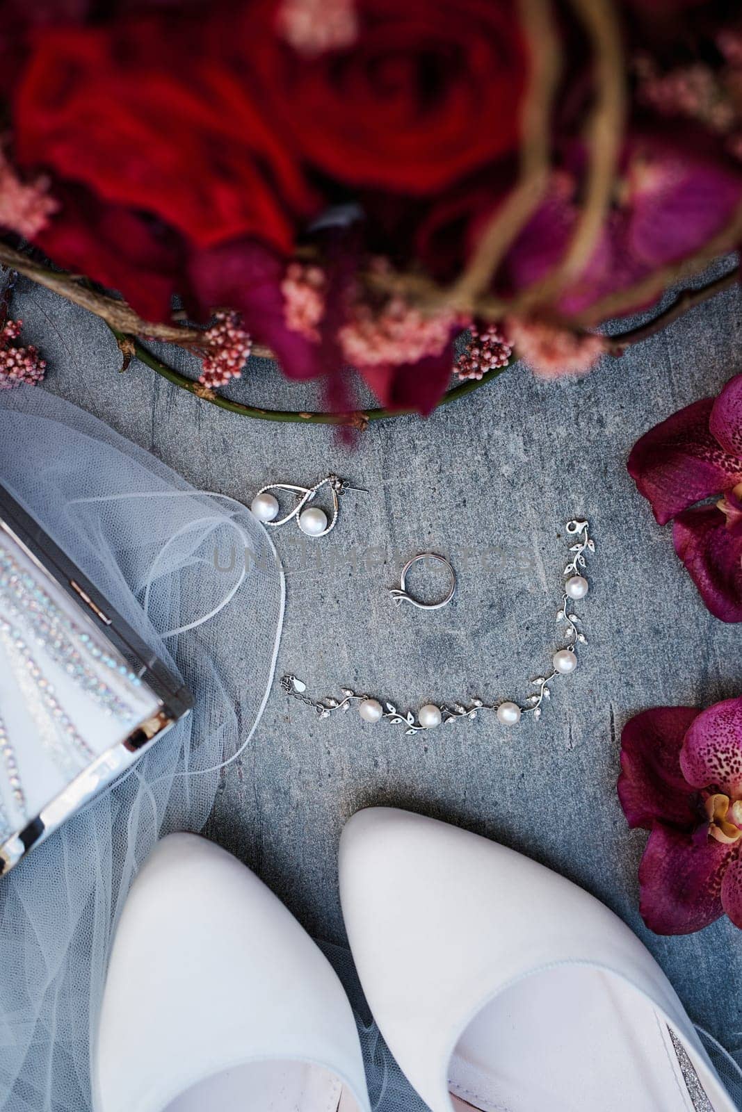 Pearl earrings and a bracelet lie next to the wedding ring on the table. Top view. High quality photo