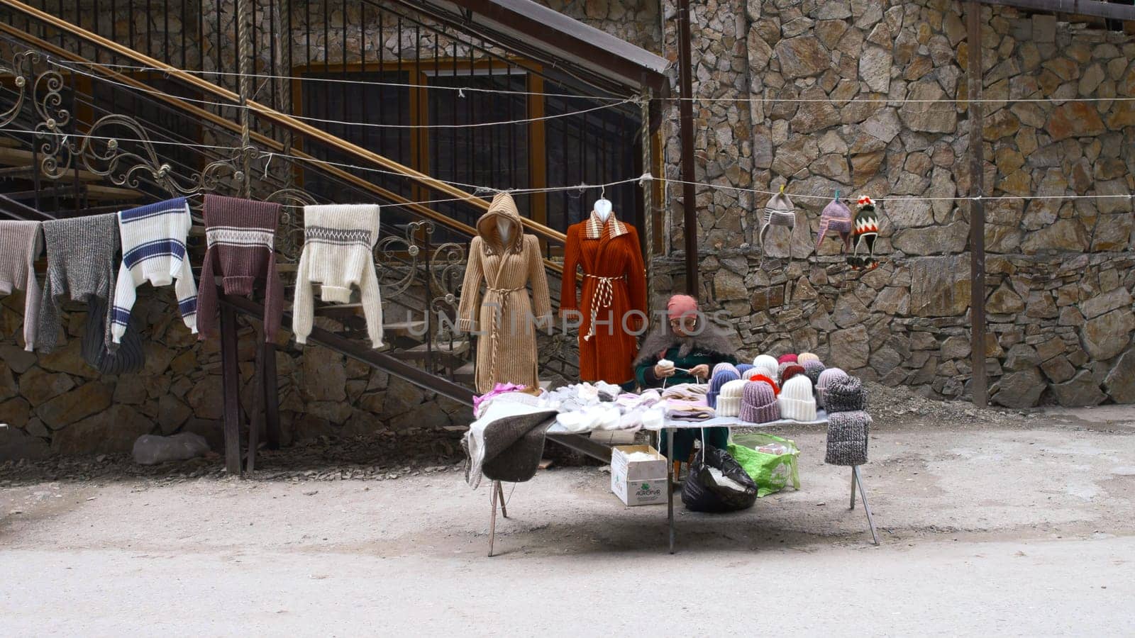 Georgia, Tbilisi - September 26, 2023: Bazaar with people in mountains. Stock footage. Tourist bazaar with souvenirs among rocky mountains. Souvenirs are sold high in mountains at foot of cliffs.Traveling in mountains.