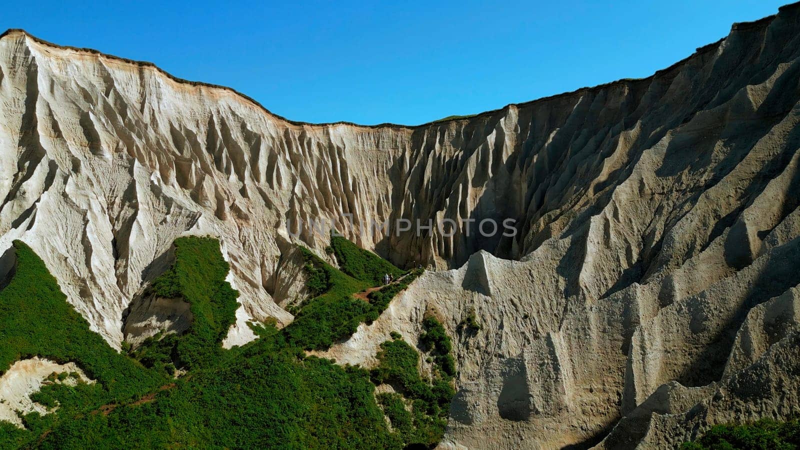 Beautiful aerial of the white cliffs on the south coast of England. Clip. Green summer forested hills and blue sky. by Mediawhalestock
