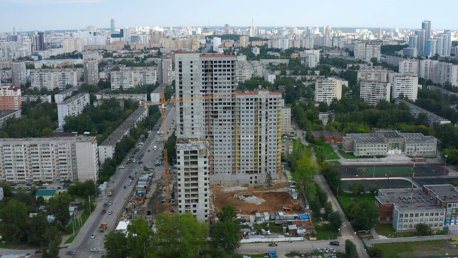 Top view of construction of multi-storey building in city. Stock footage. Construction of multi-storey building in city center on summer day. Panorama of modern city with construction of high-rise buildings by Mediawhalestock
