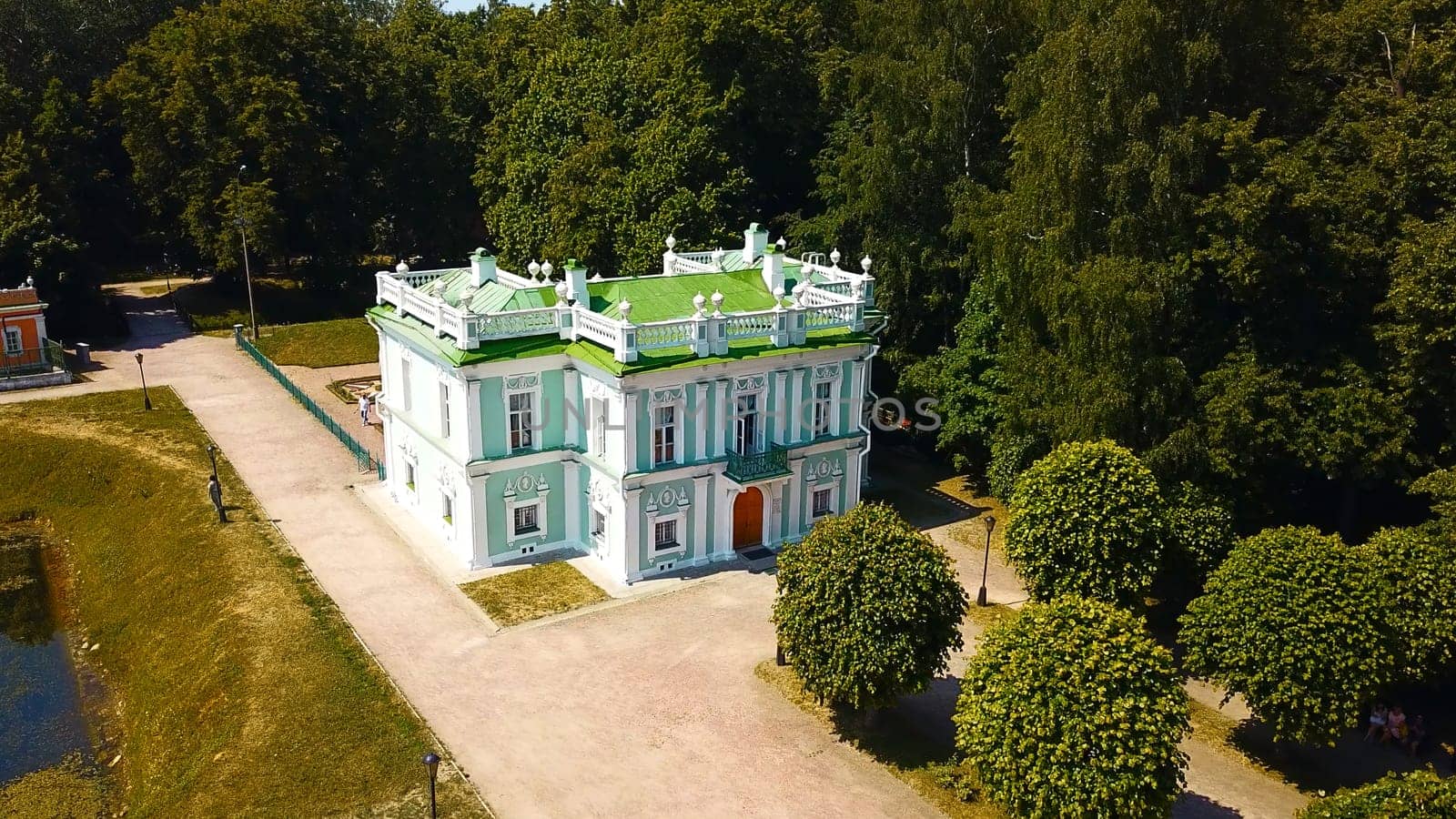 Top view of historic building with garden and pond. Creative. Beautiful park and garden with Baroque estate. Tourists walk in historical park with ancient building by Mediawhalestock