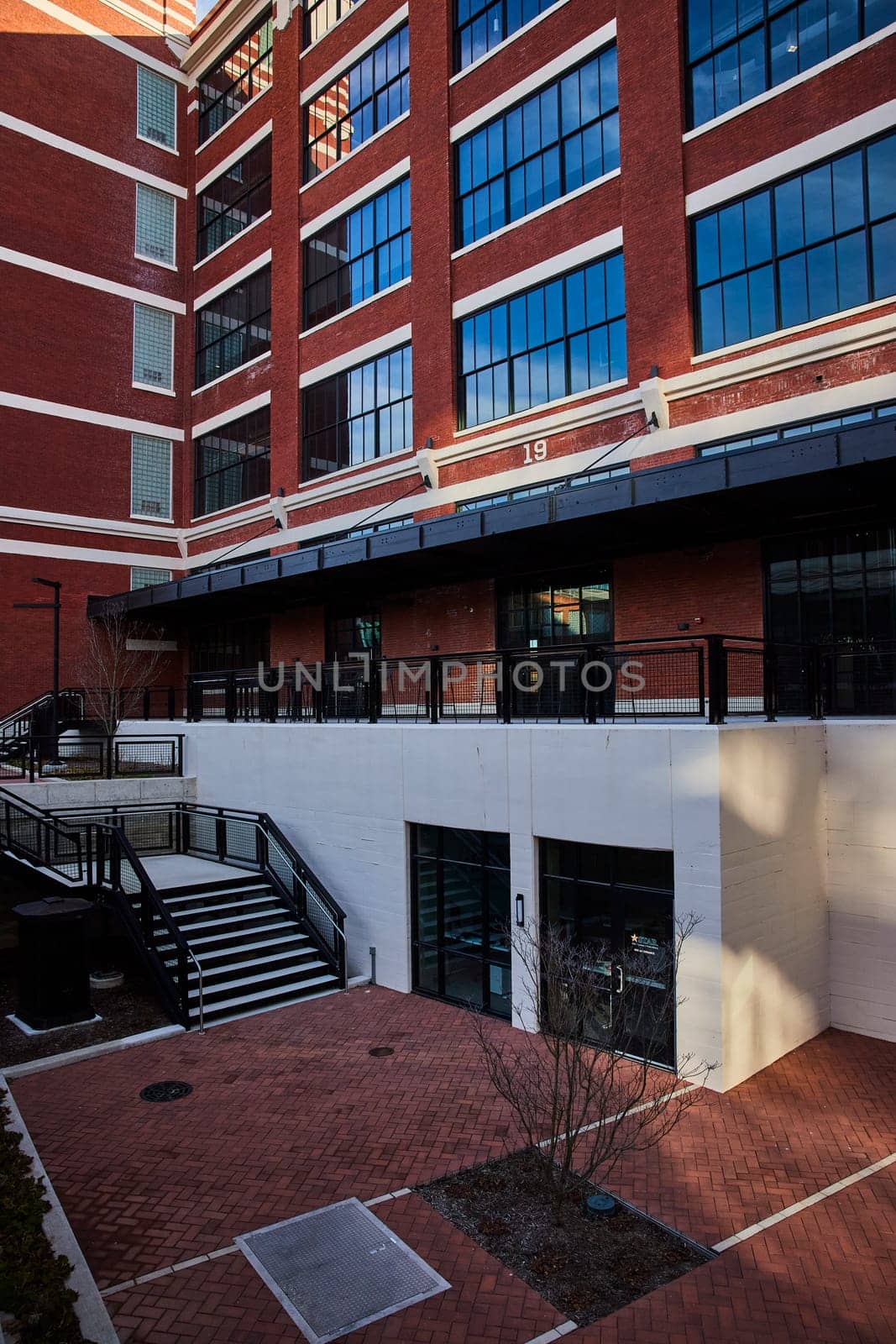 Daylight view of the distinctive red brick Electric Works building in Fort Wayne, Indiana, showcasing urban architectural design and development.