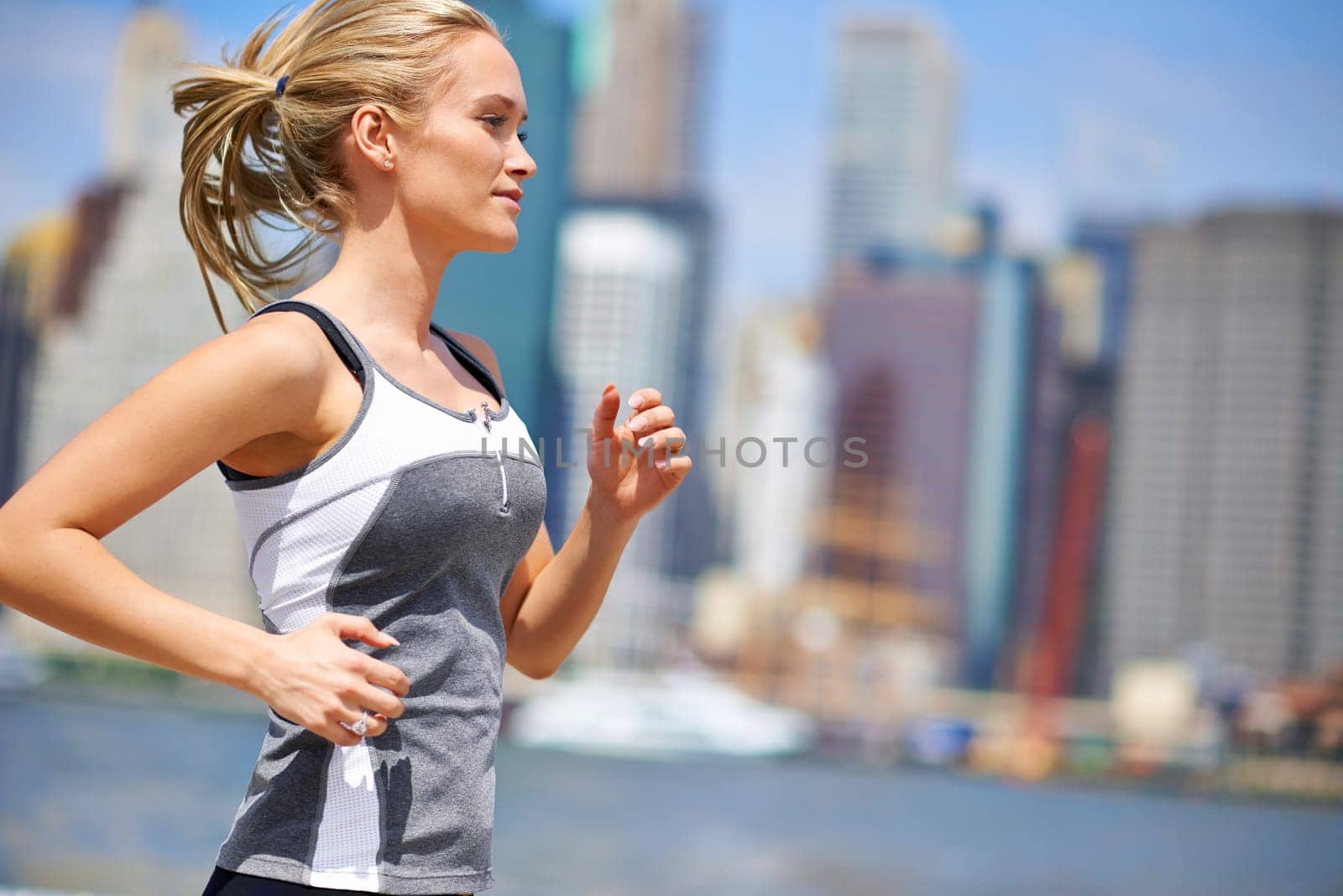 Woman, strong and running for fitness in city, jogging active and fit female person exercising in New York. Energy, marathon for sports training and workout for athlete, cardio for endurance by YuriArcurs
