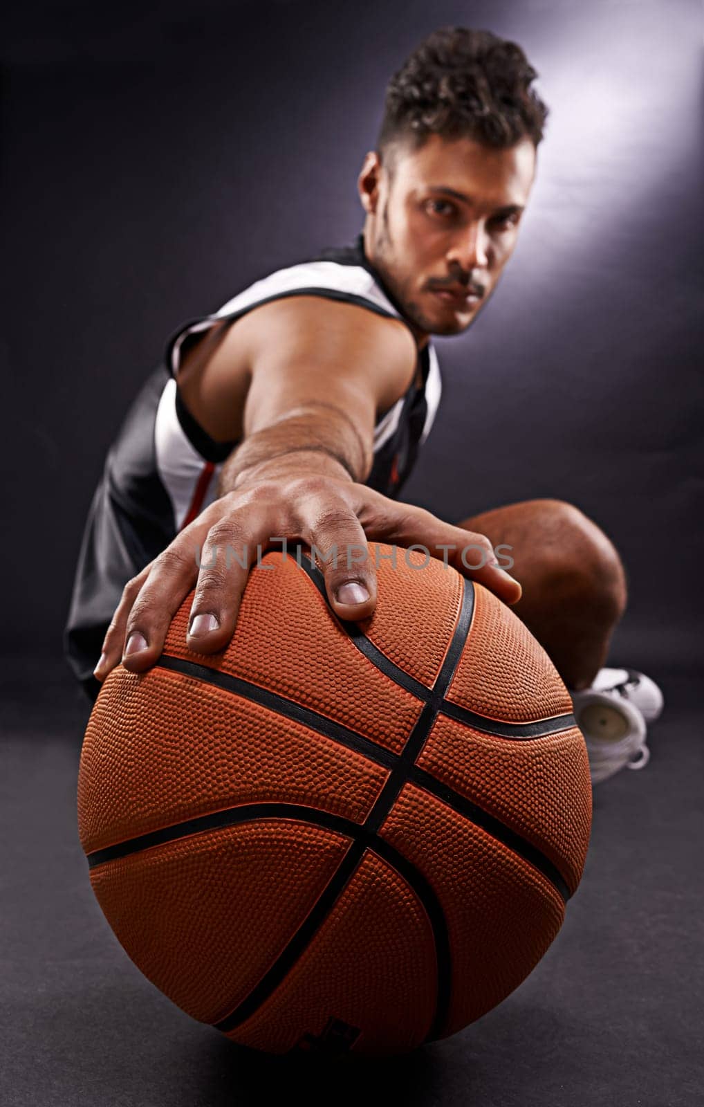 Man, portrait and basketball playing for sports game in studio or professional exercise, athlete or black background. Male person, training and fitness pride or workout competition, uniform or mockup by YuriArcurs