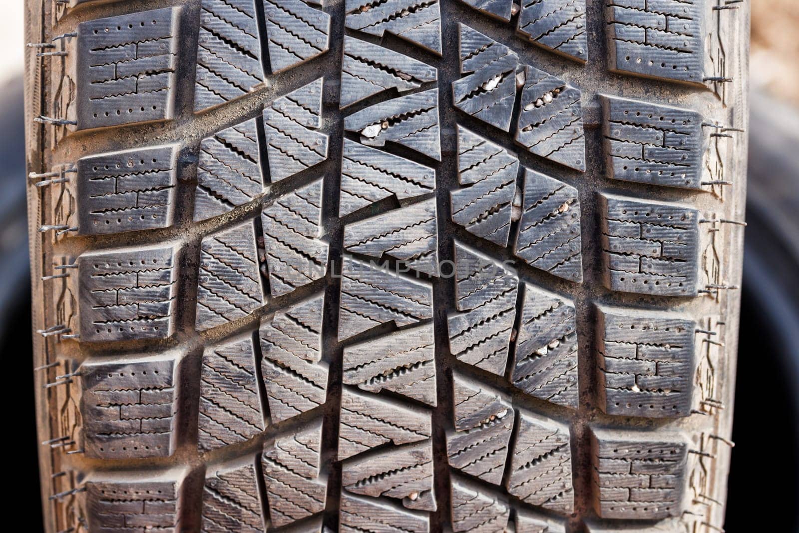 small rocks stuck in car tire tread, closeup by z1b
