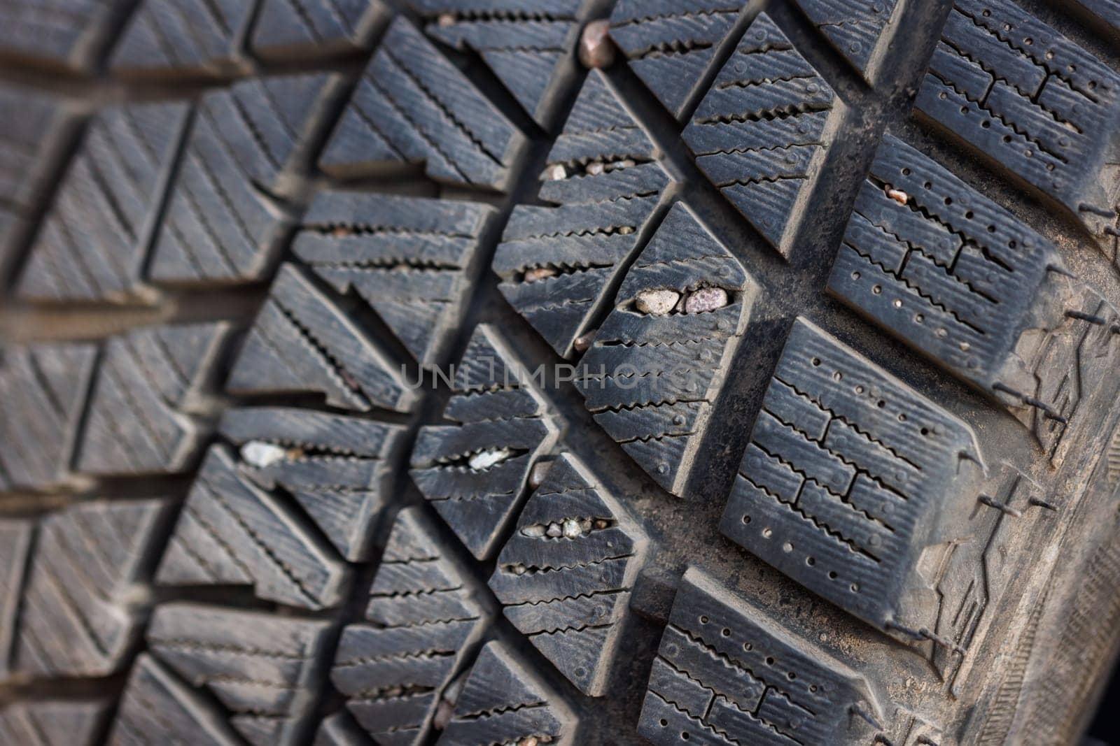 small rocks stuck in car tire tread, closeup by z1b