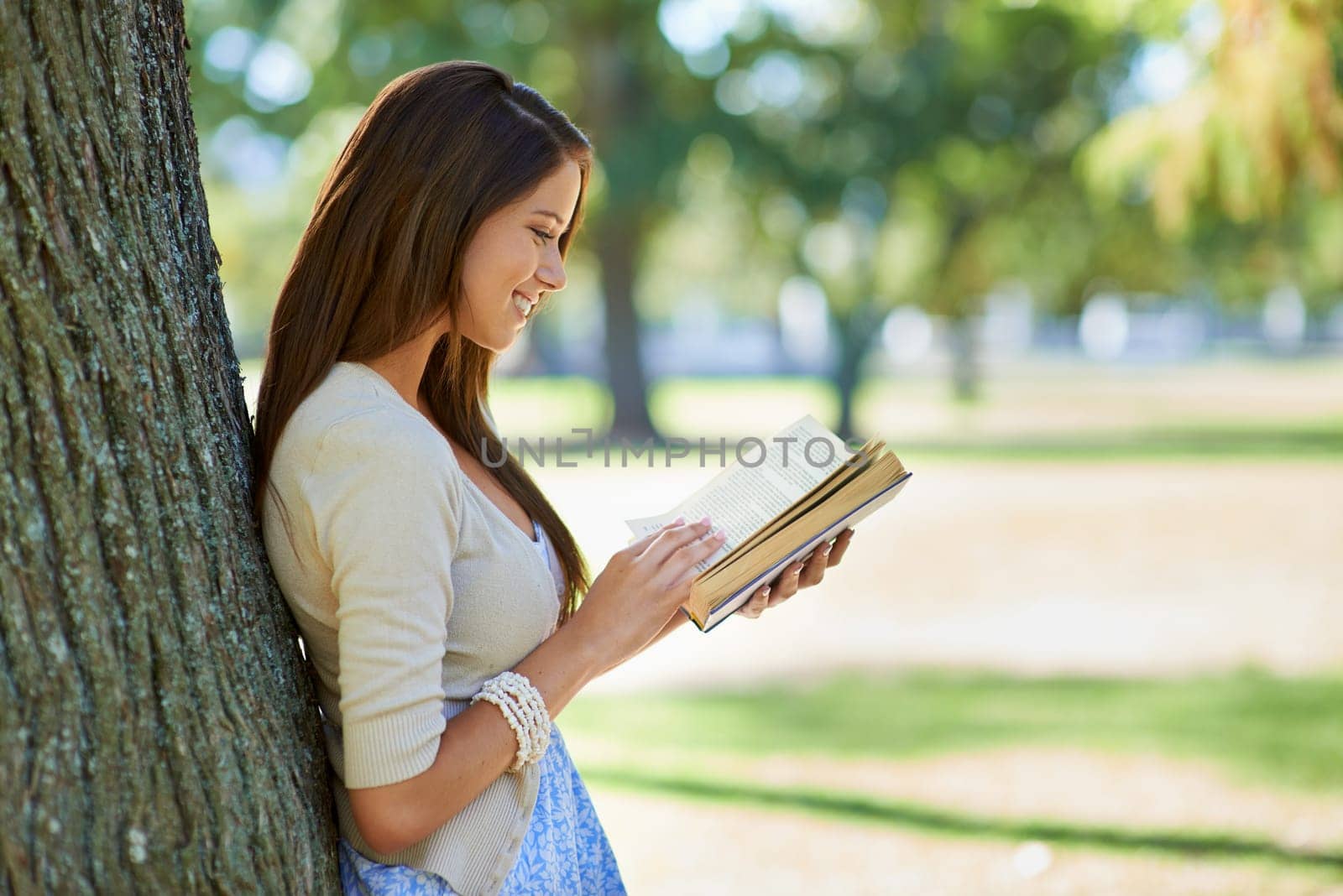 Happy woman, park and reading book for learning, education or leisure in summer. Young person with story, fiction or literature for language, knowledge and studying or creative inspiration in nature.