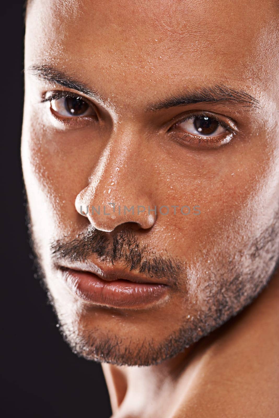 Portrait, skincare and man in studio closeup for wellness, dermatology or skin cleaning on black background. Face, water and male model with masculine beauty, cosmetics or facial splash treatment by YuriArcurs