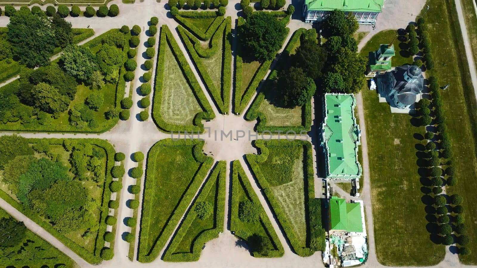 Top view of royal garden with patterns and ancient buildings. Creative. Amazing beauty of garden pattern and trails of royal palace. Territory of old rich estate with garden on sunny summer day by Mediawhalestock