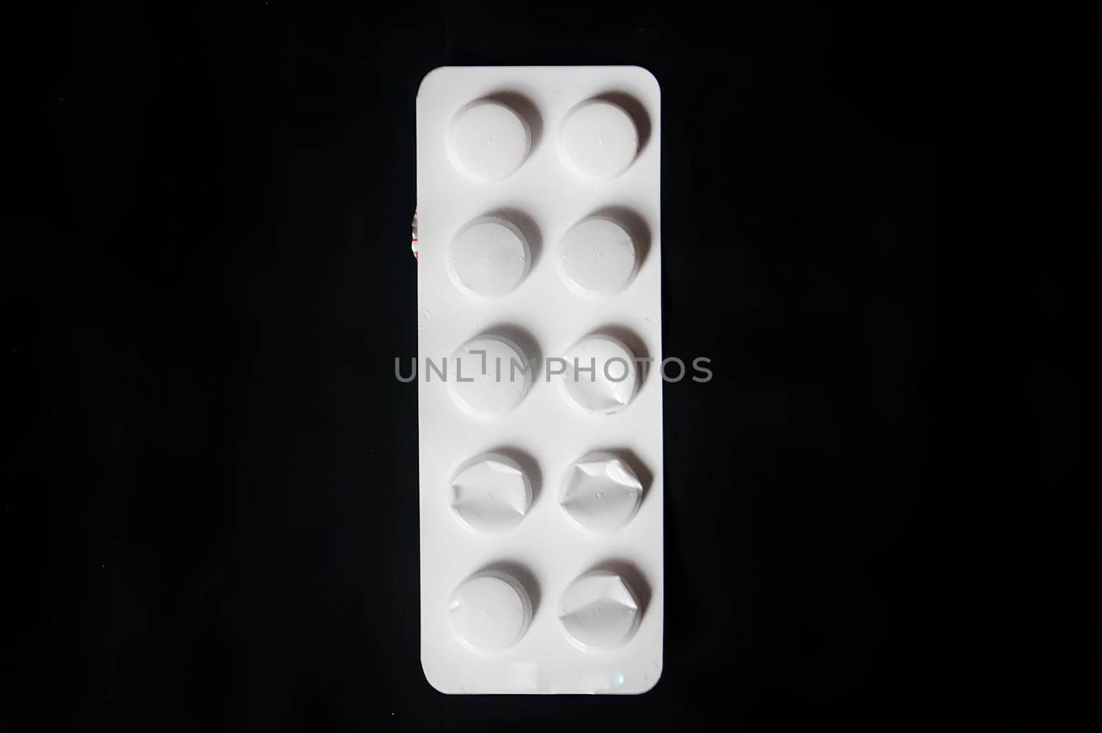 A white pill bottle with a black background. High quality photo