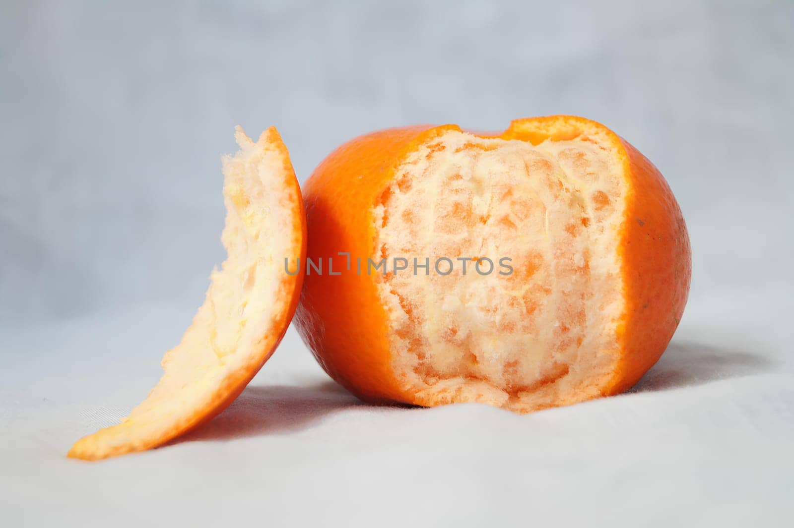 A peeled orange with a bite taken out of it. High quality photo