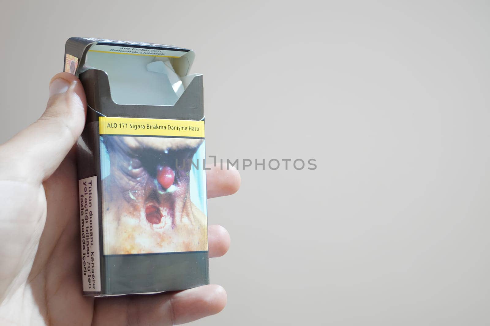 A hand holding a cigarette box. High quality photo