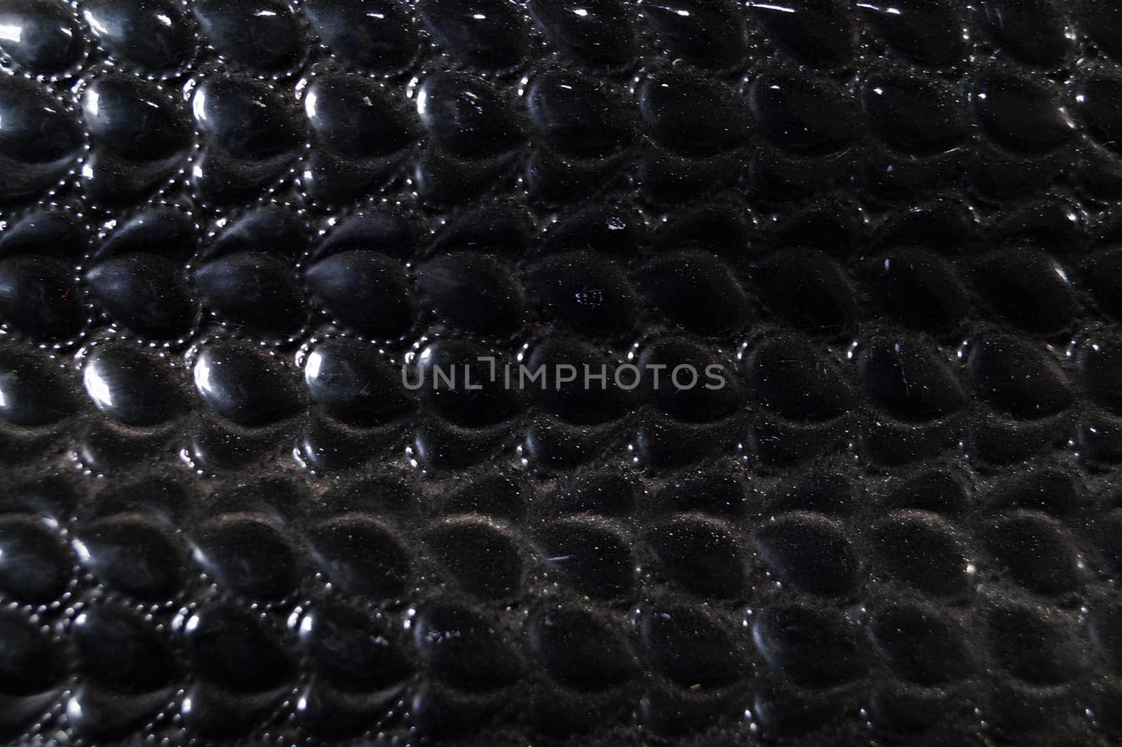 A close up of a black leather item with a pattern of small black dots by gadreel