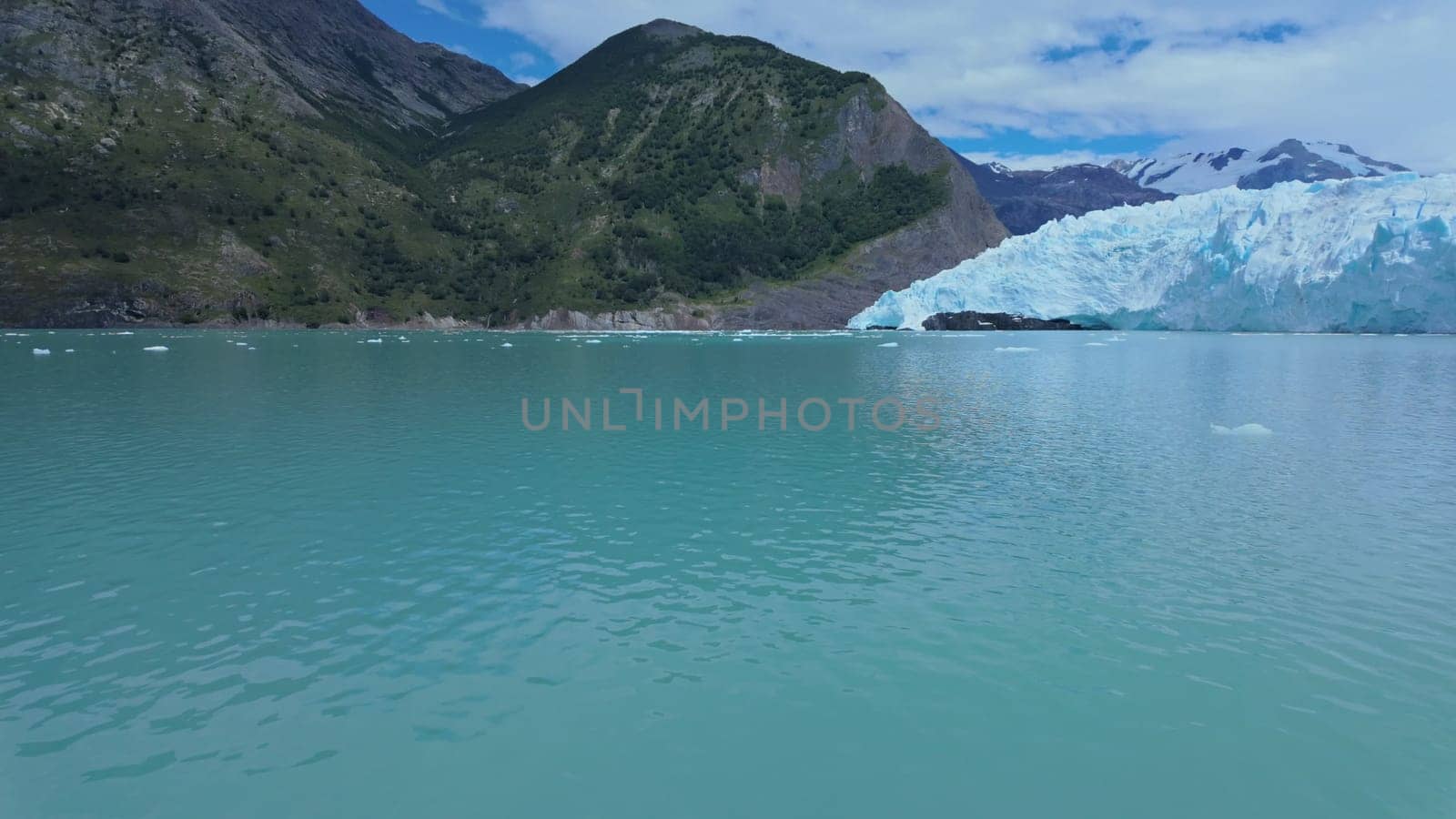 Tranquil video of a trip across a turquoise glacial lake framed by towering mountains.