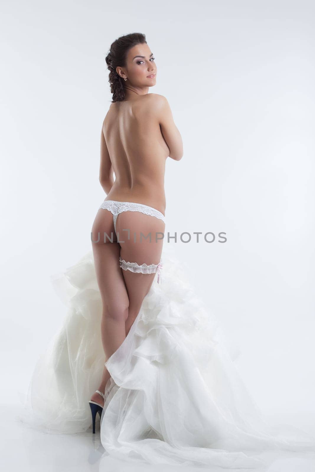 Sexy bride in lingerie posing back to camera, isolated on white
