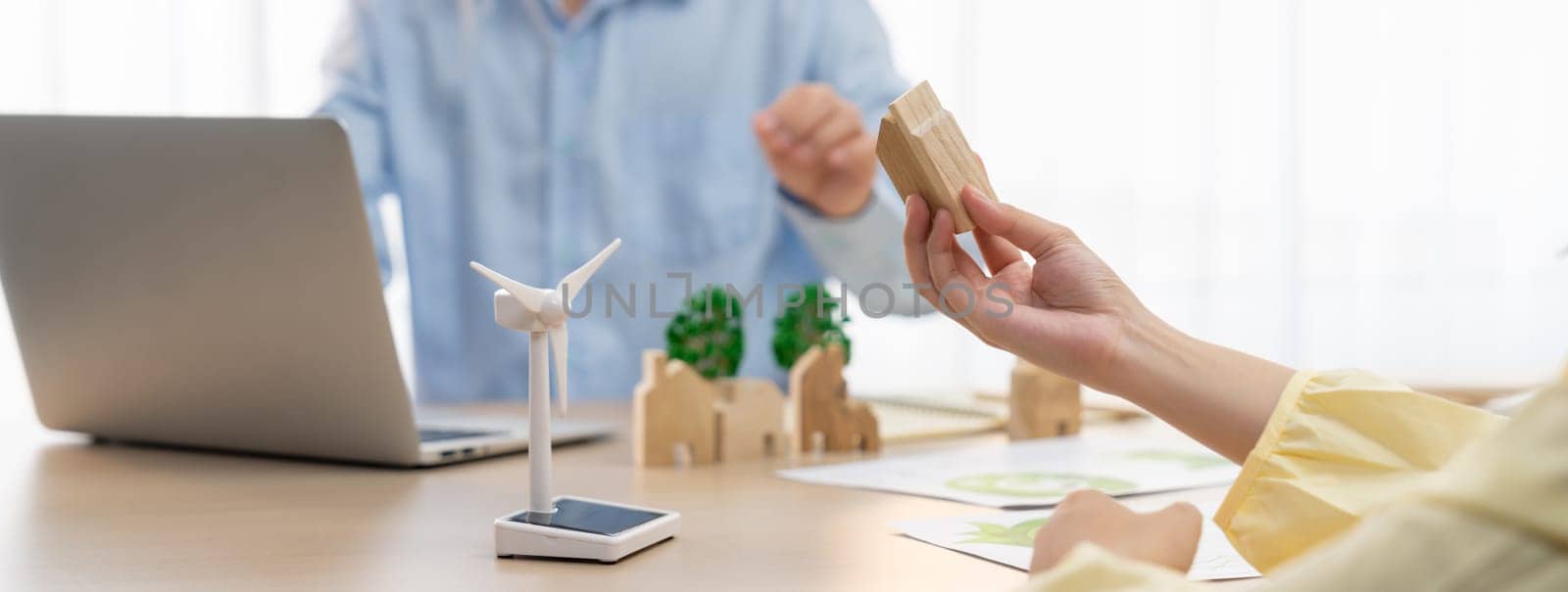 Businesswoman decides to Invest in green business. Skilled architects plan to build a eco house by using renewable energy at table with environmental document scatter around. Close up. Delineation.