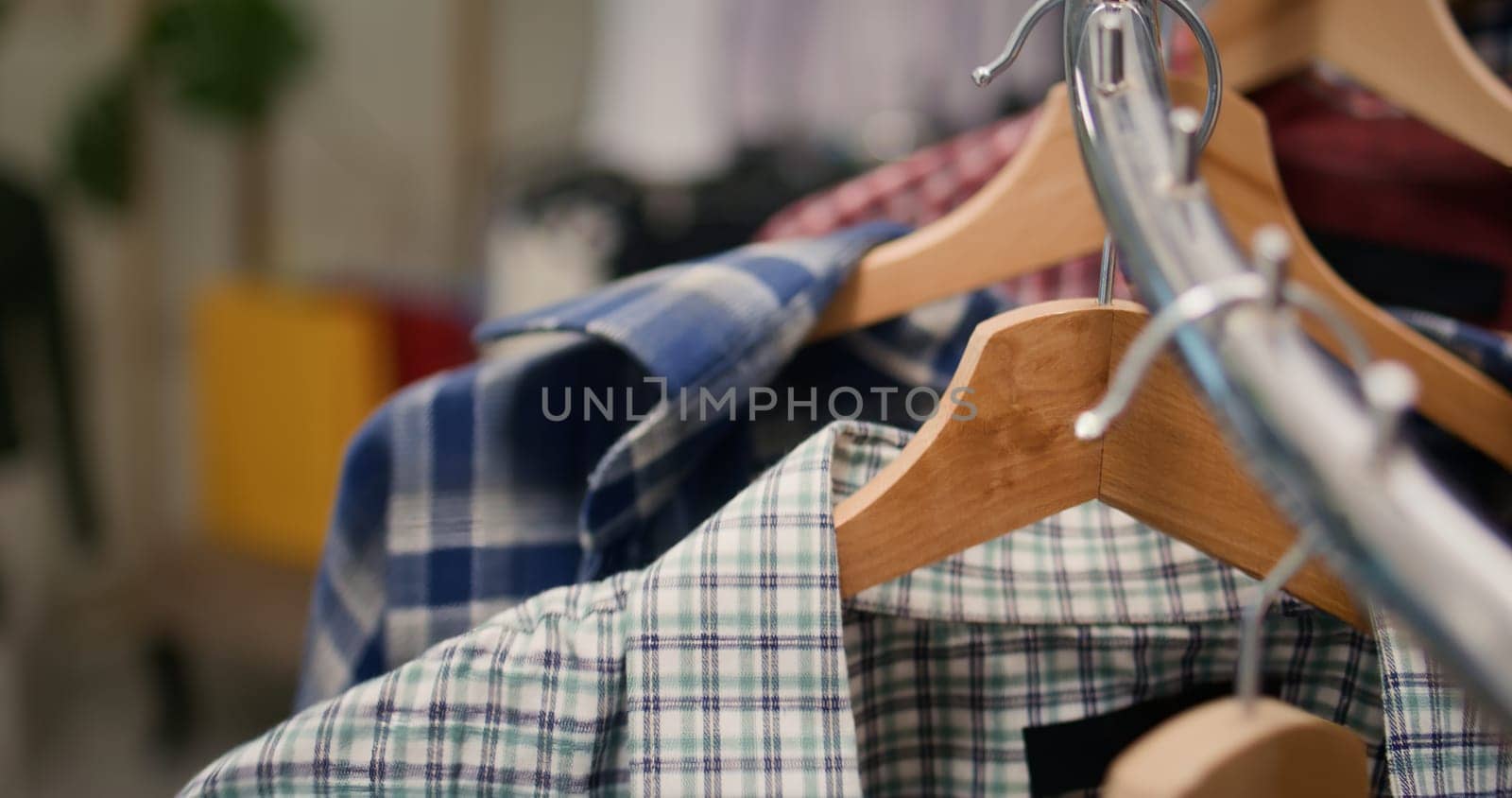 Extreme close up shot of stylish selection of shirts on hangers in high end fashion boutique showcasing trendy garments from new collection. Men shirts rotating on clothing store rack