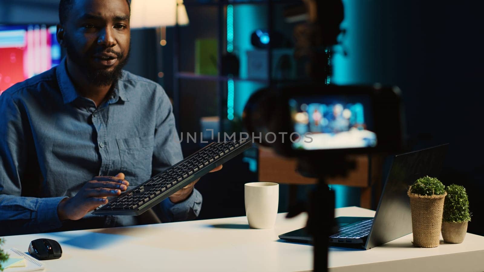 Content creator in living room studio films mechanical keyboard review for online streaming platforms. Trending media star hosts technology focused internet show, unboxing computer peripherals