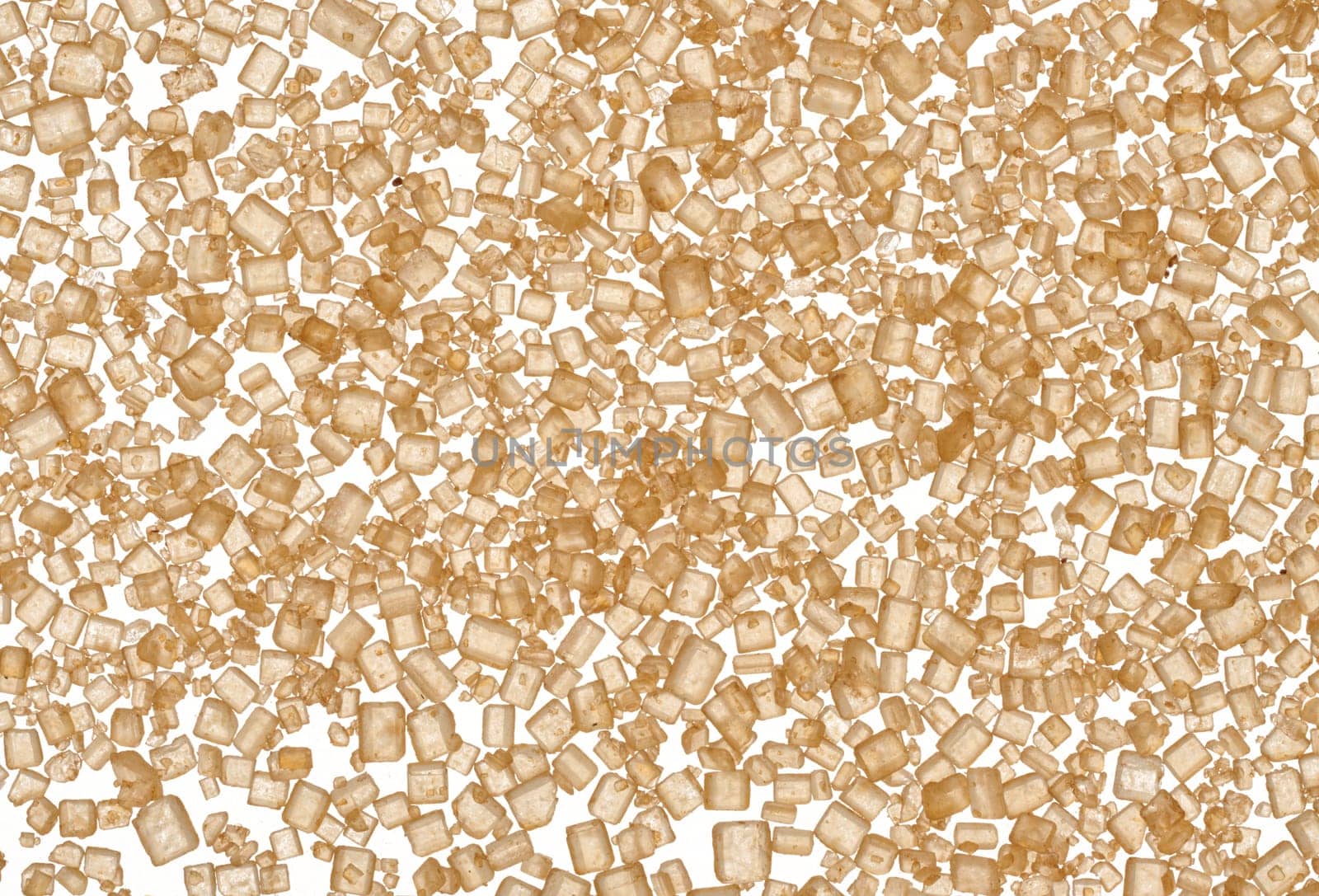 Brown cane sugar granules on isolated background, top view