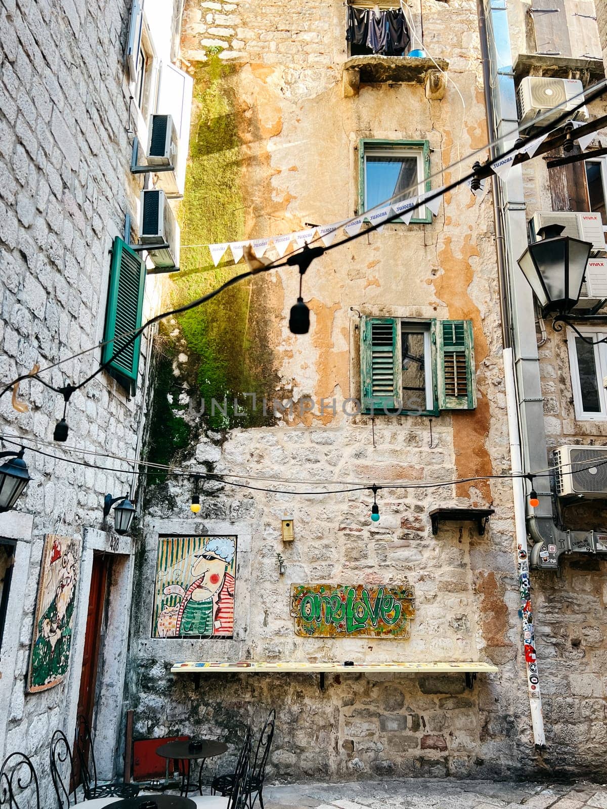Vintage facade of a stone high-rise building with shutters, paintings and air conditioners. High quality photo