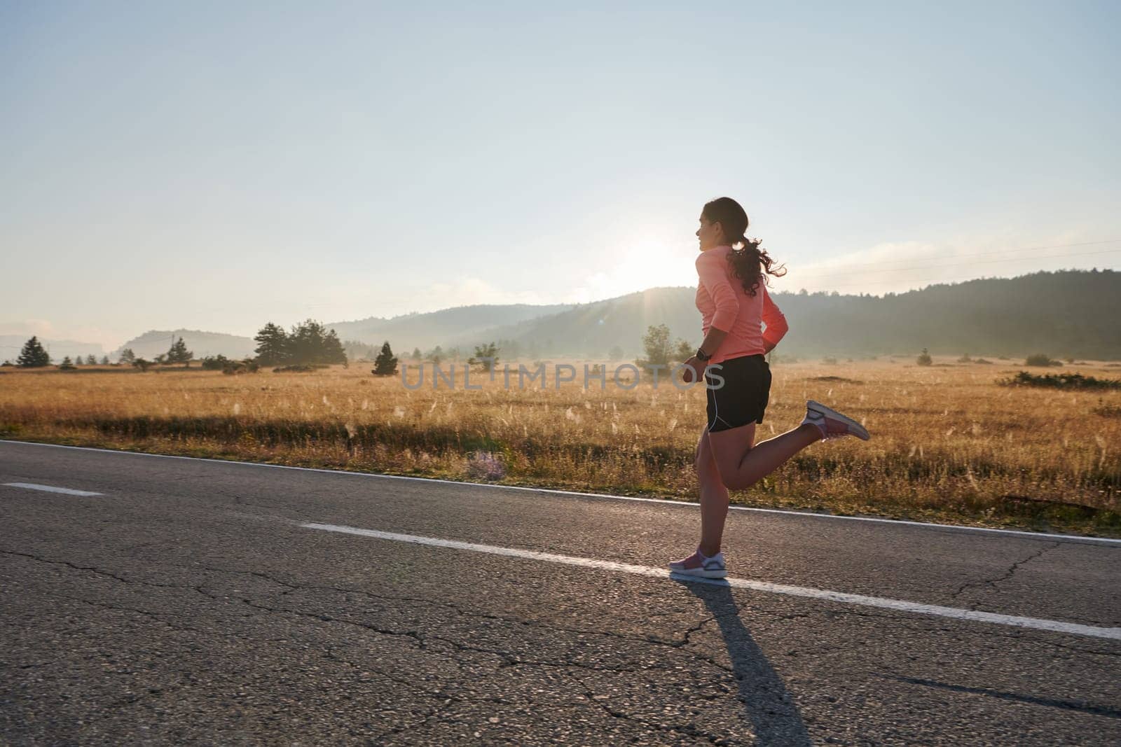 Determined Dawn: Confident and Motivated Athlete Embarks on Sunrise Run. by dotshock