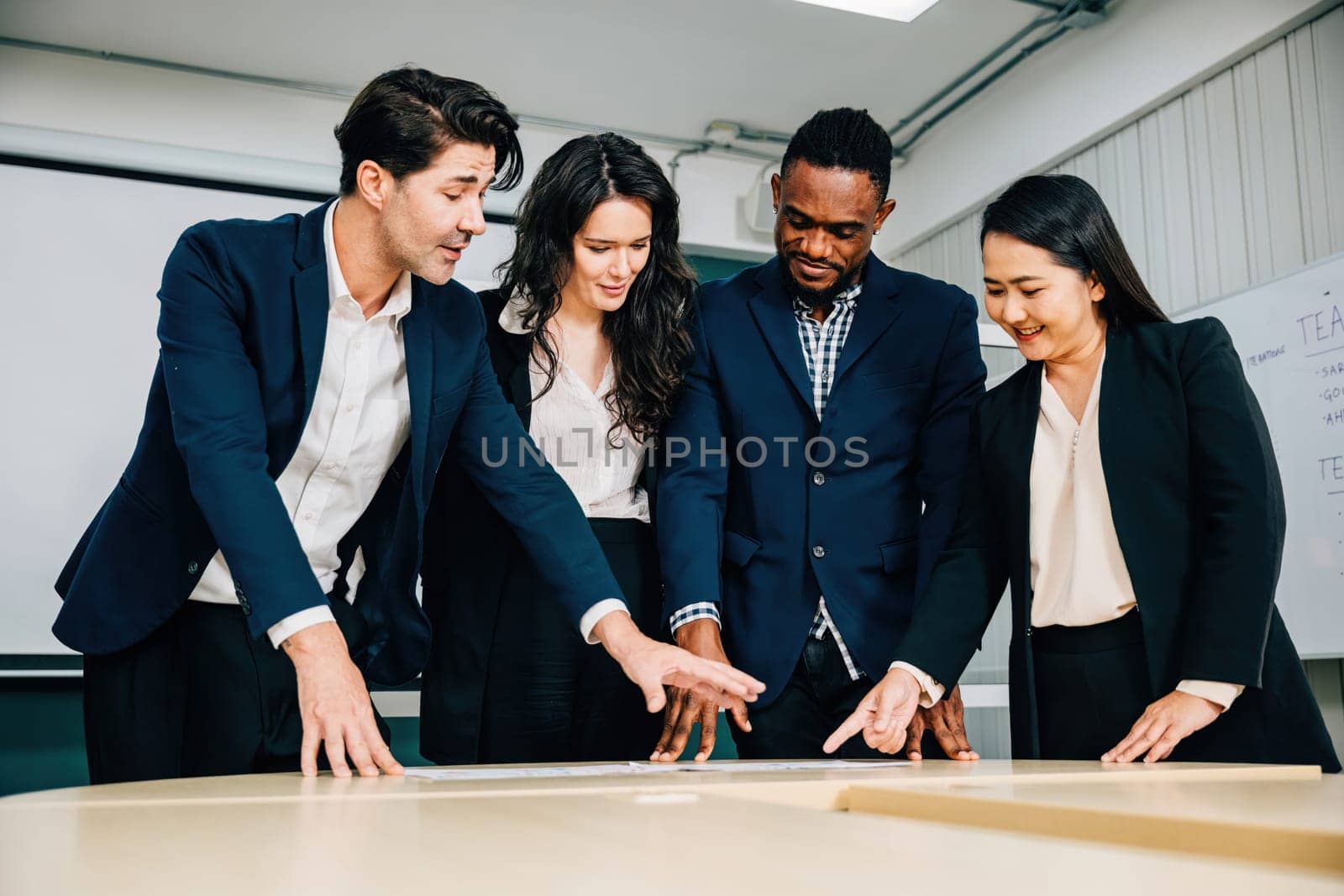 A group of professionals stands in a conference room, engaged in a successful meeting. Teamwork, planning, and smiles underscore their commitment to business success.