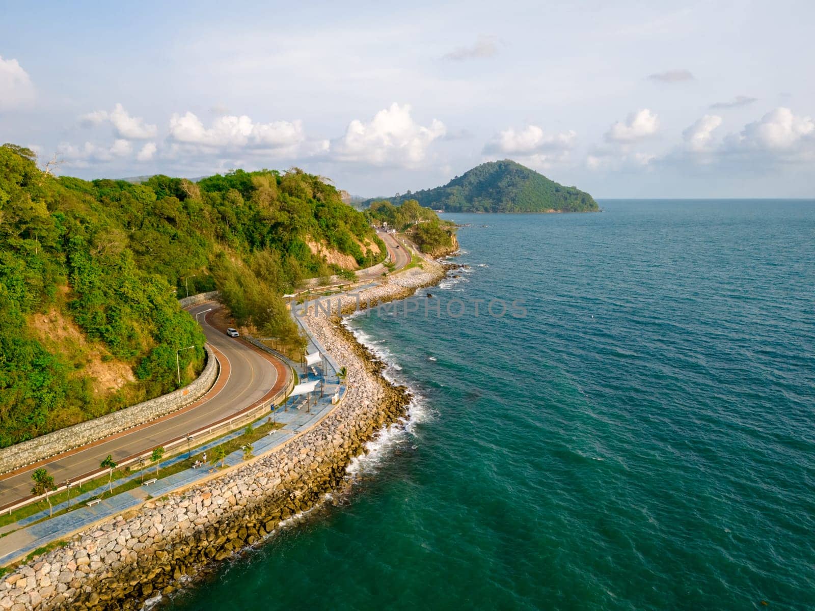 car driving on the curved road of Thailand. road landscape in summer. it's nice to drive on the beachside highway. Chantaburi Province Thailand, coastal road alongside the ocean