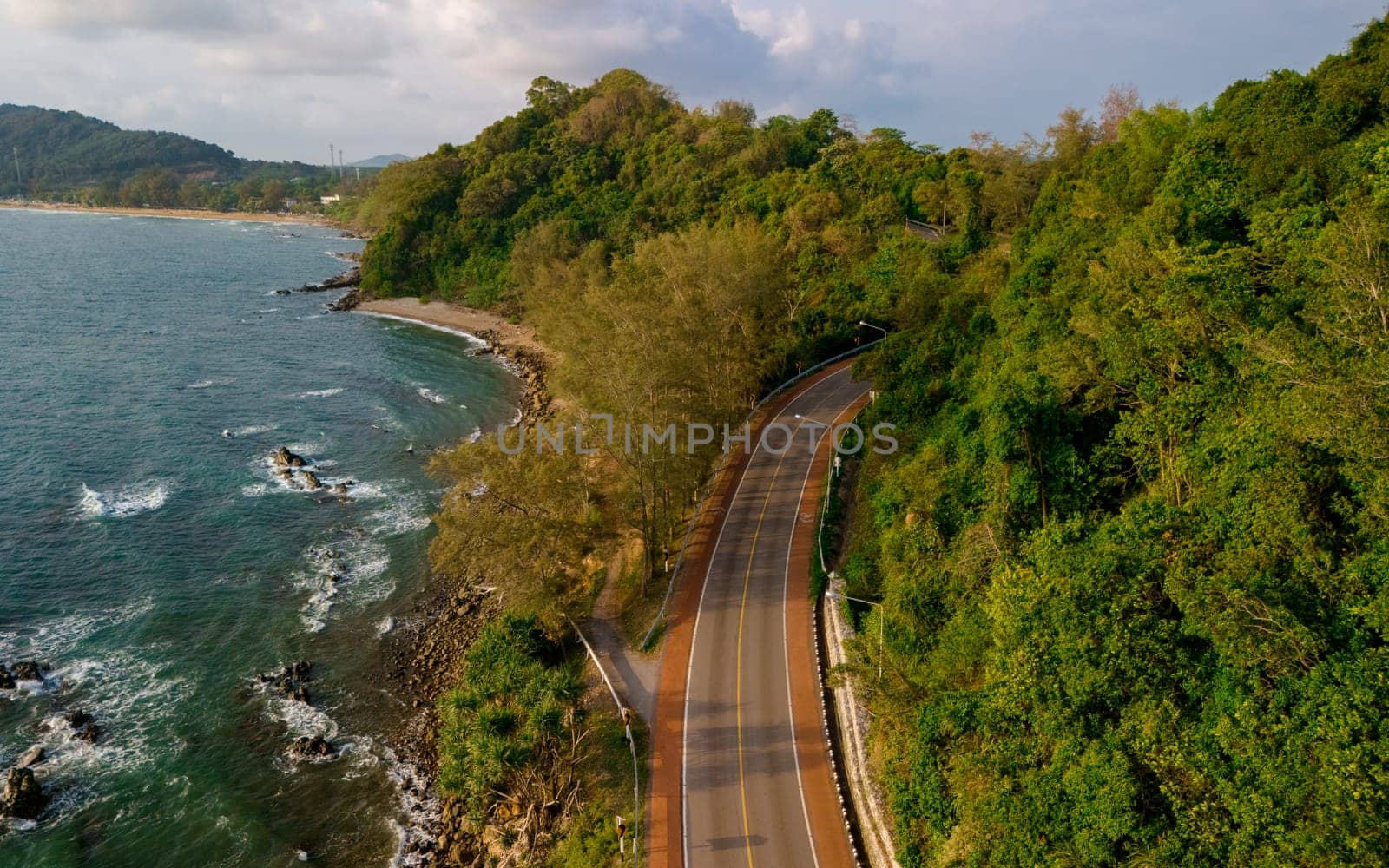car driving on the curved road of Thailand. road landscape in summer. it's nice to drive on the beachside highway. Chantaburi Province Thailand, drone view at the road in the mountains