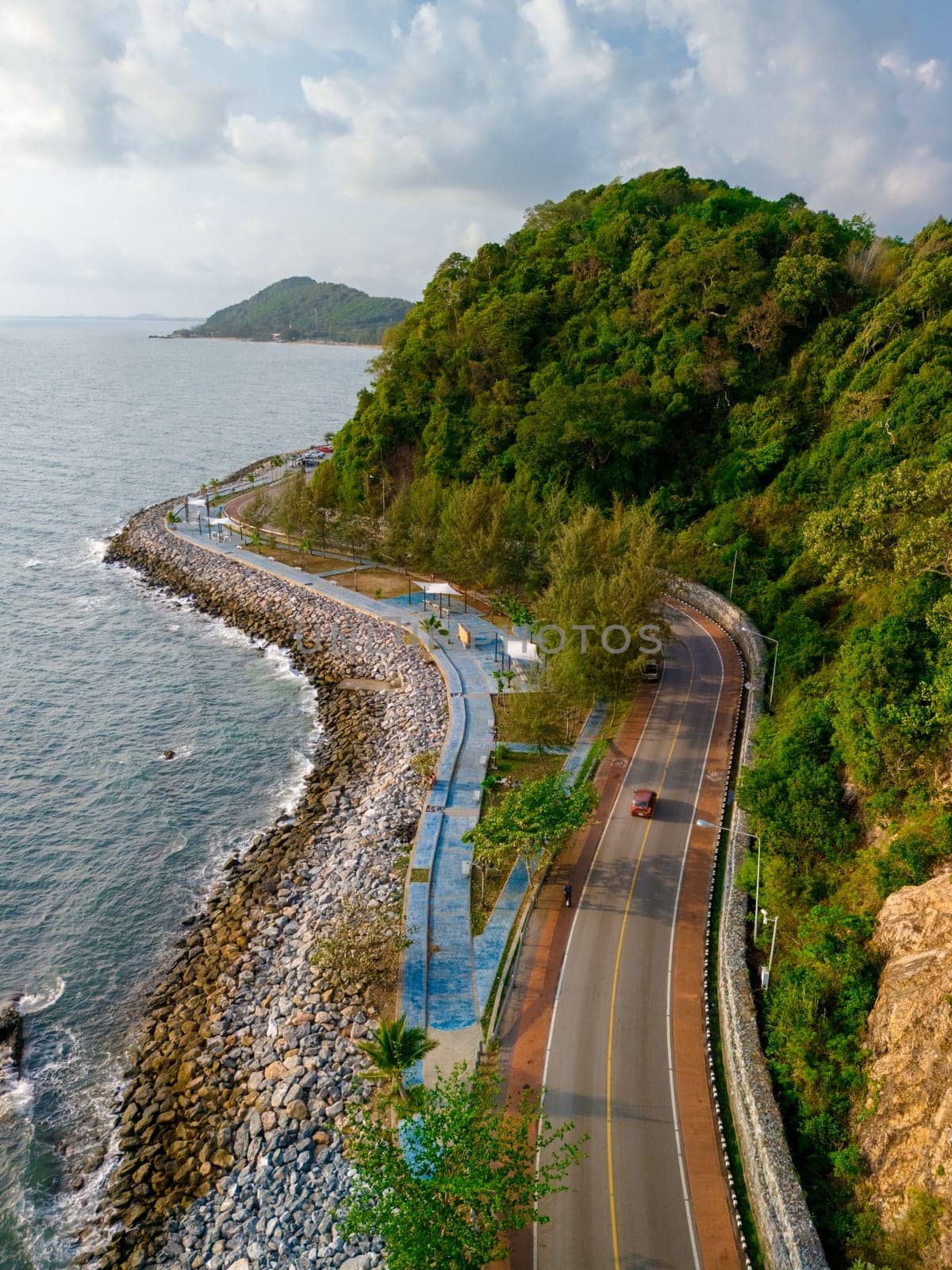 car driving on the curved road alongside the ocean beach road of Thailand. road landscape in summer. it's nice to drive on the beachside highway. Chantaburi Province Thailand at sunset