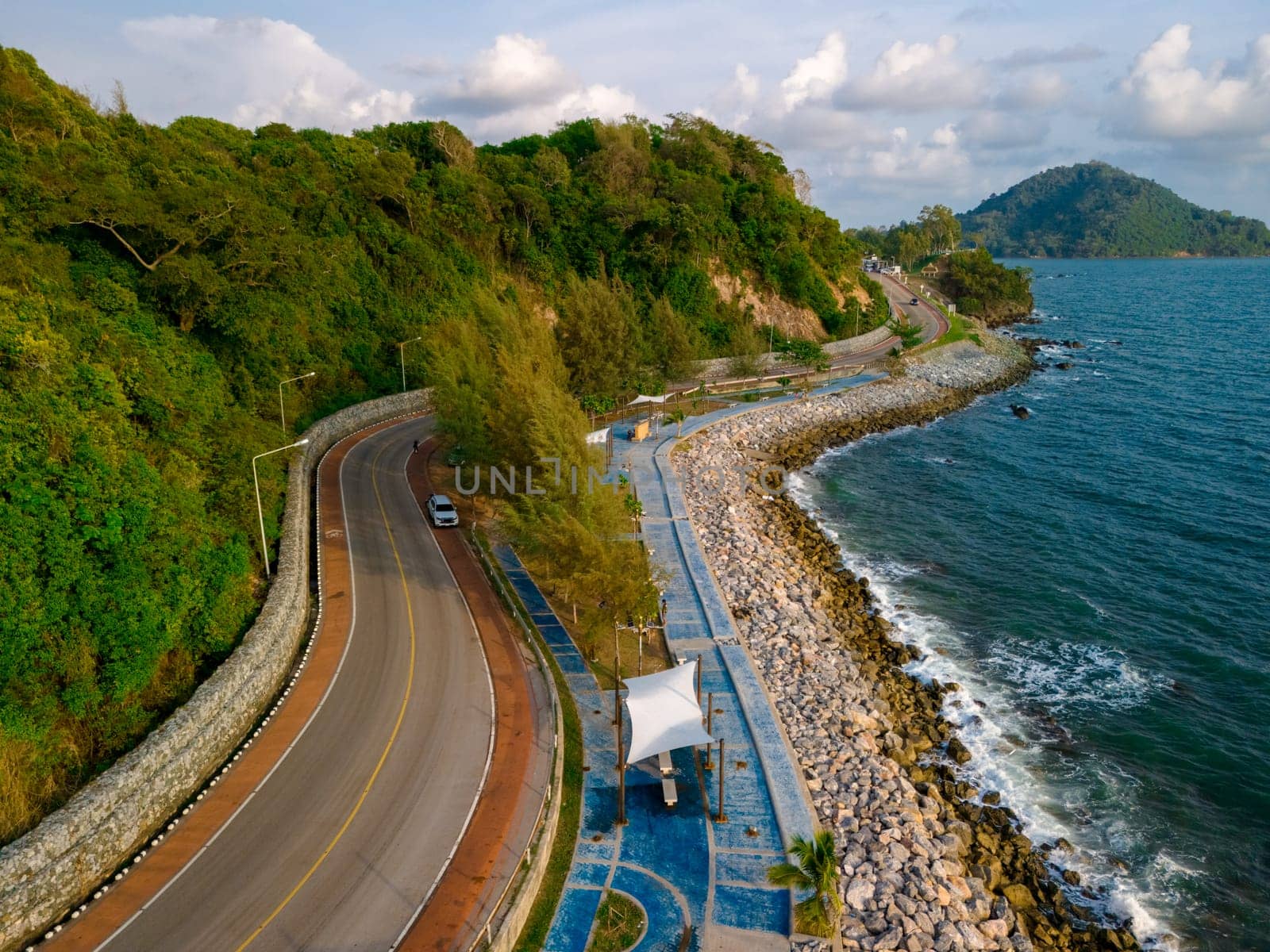 car driving on the curved road alongside the ocean beach road of Chantaburi Province Thailand,