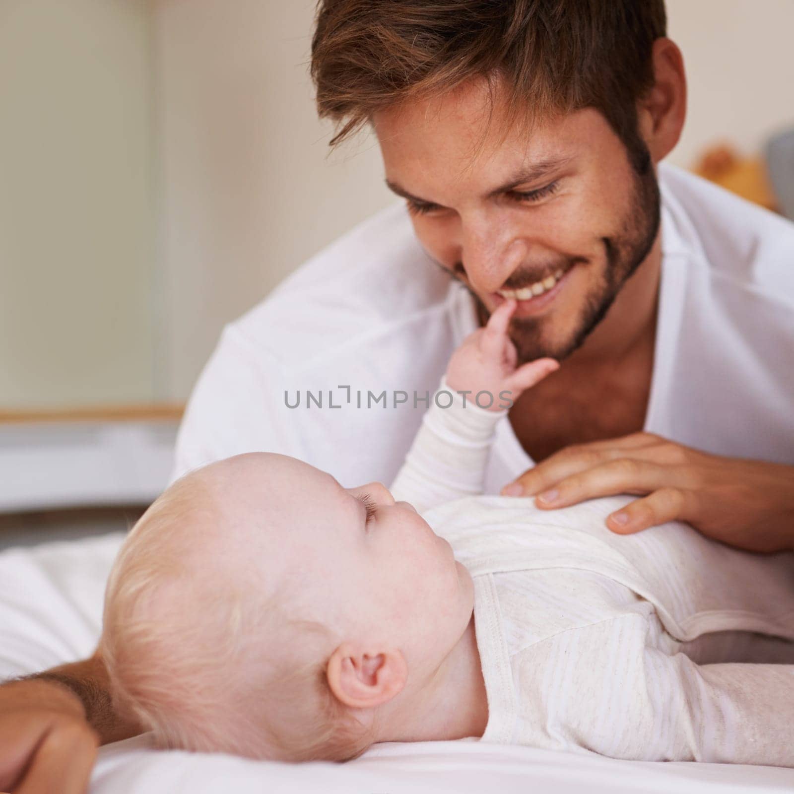 Smile, sweet and baby with father on bed relaxing, playing and bonding together at home. Happy, love and young dad laying with girl child, infant or kid in bedroom or nursery at family house