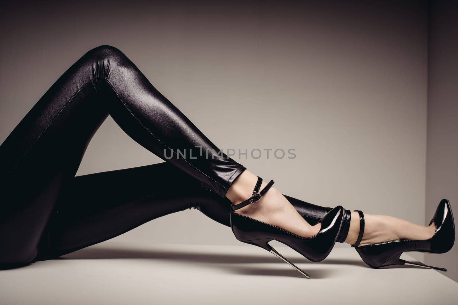 lender female legs in spandex catsuit and a fetish shoe with extremely high heels. BDSM theme.